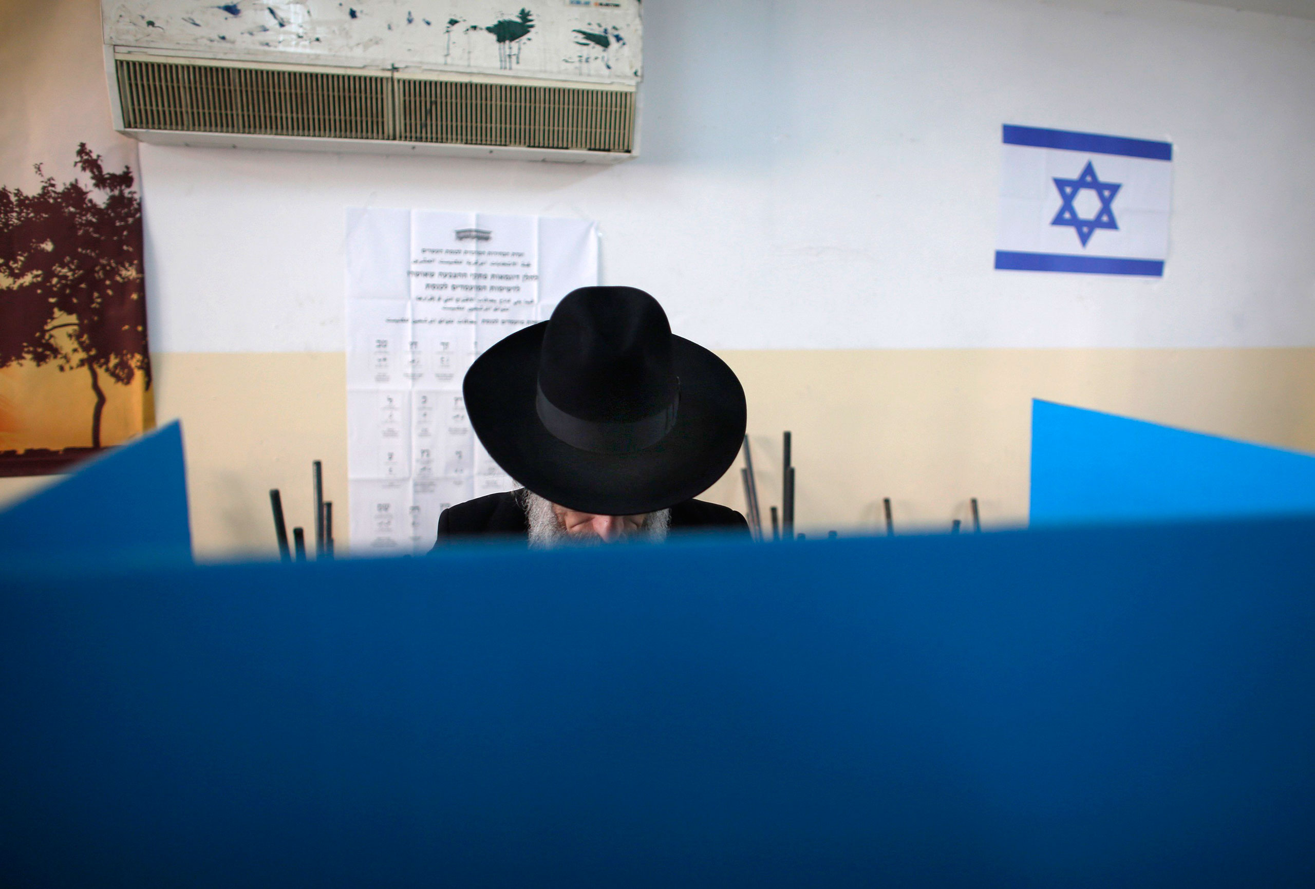 A ultra-Orthodox Jewish man stands behind a voting booth at a polling station in Jerusalem on March 17, 2015.