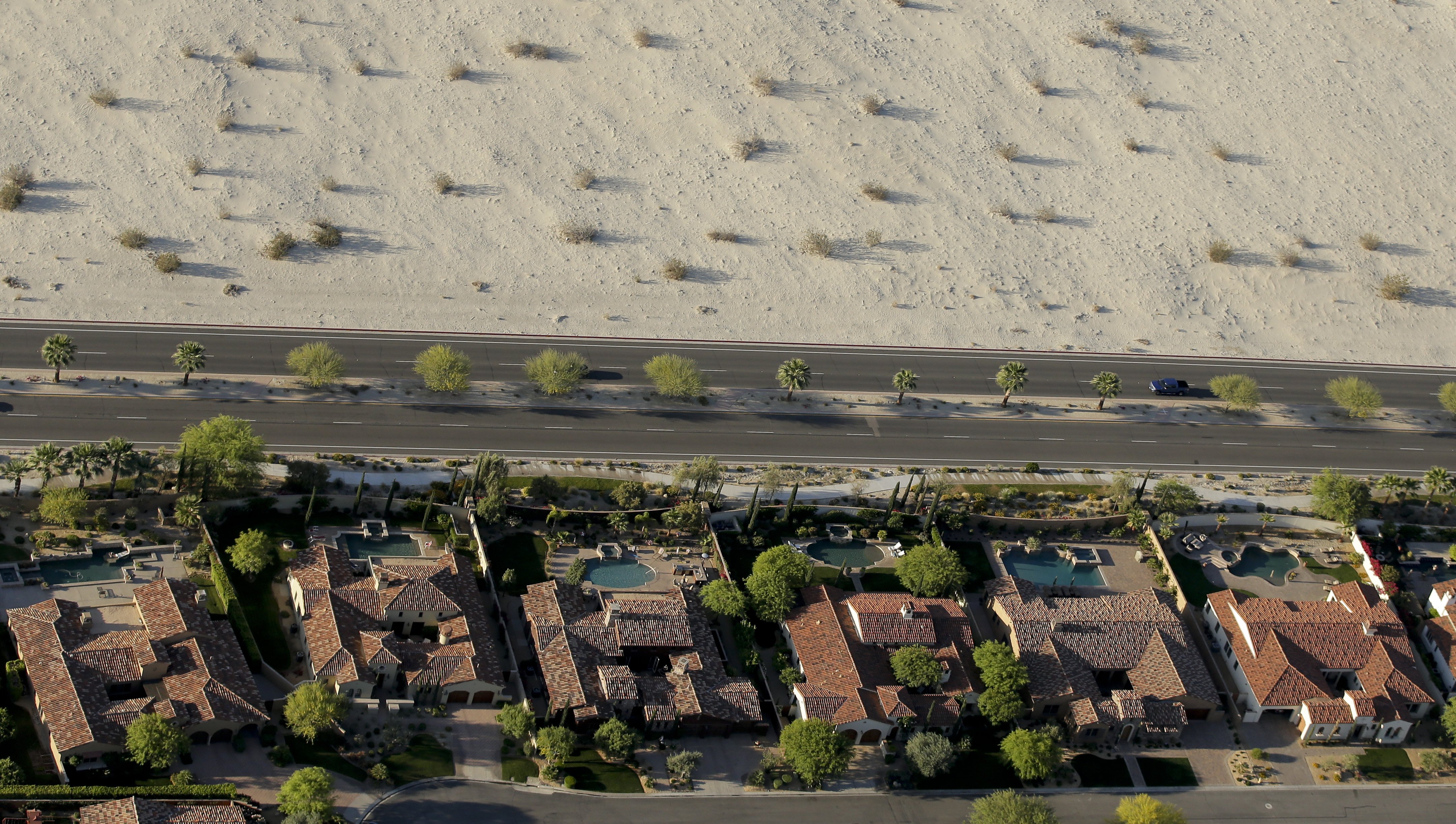 Homes with swimming pools border the desert on April 3, 2015, in Cathedral City, Calif.