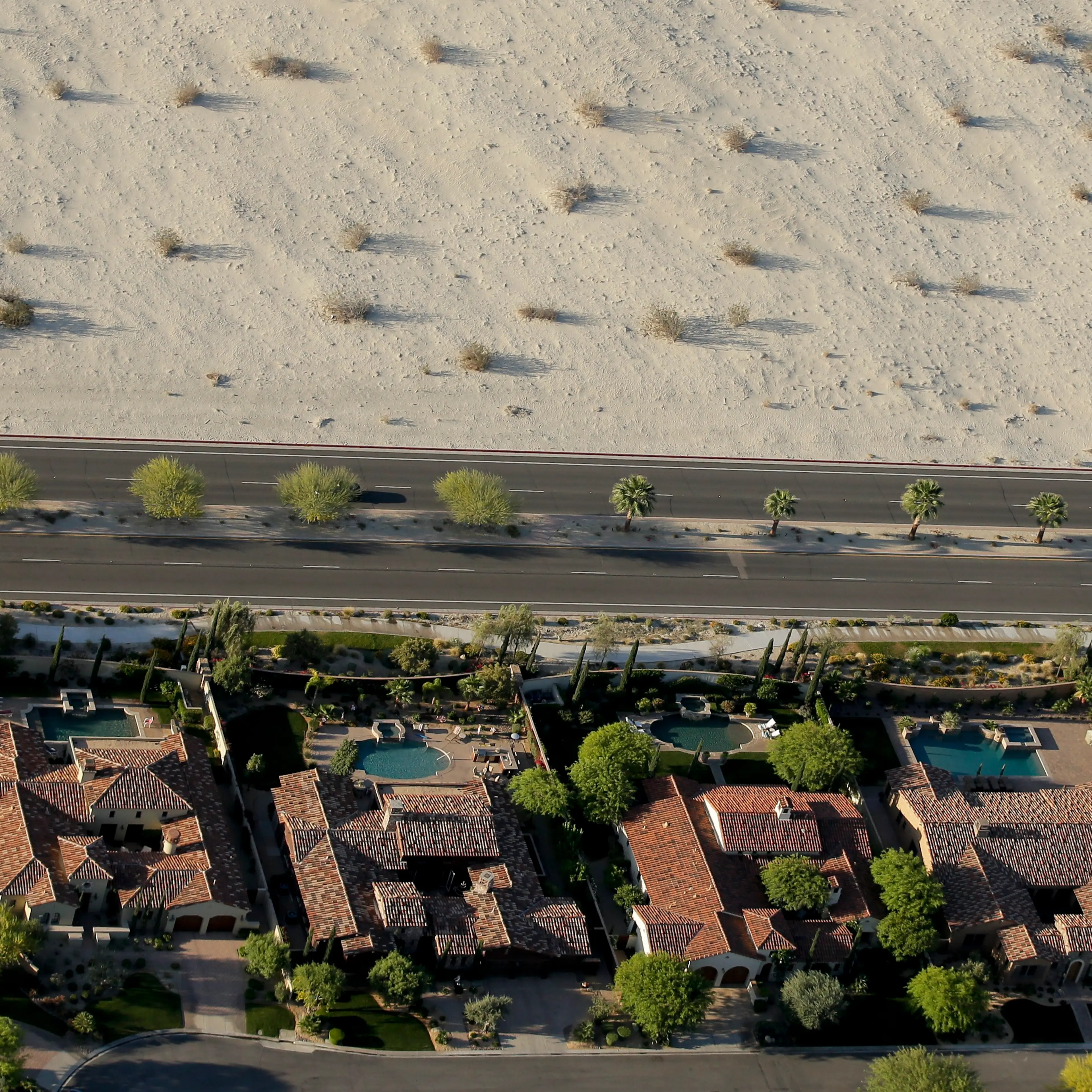 Homes with swimming pools border the desert on April 3, 2015, in Cathedral City, Calif.