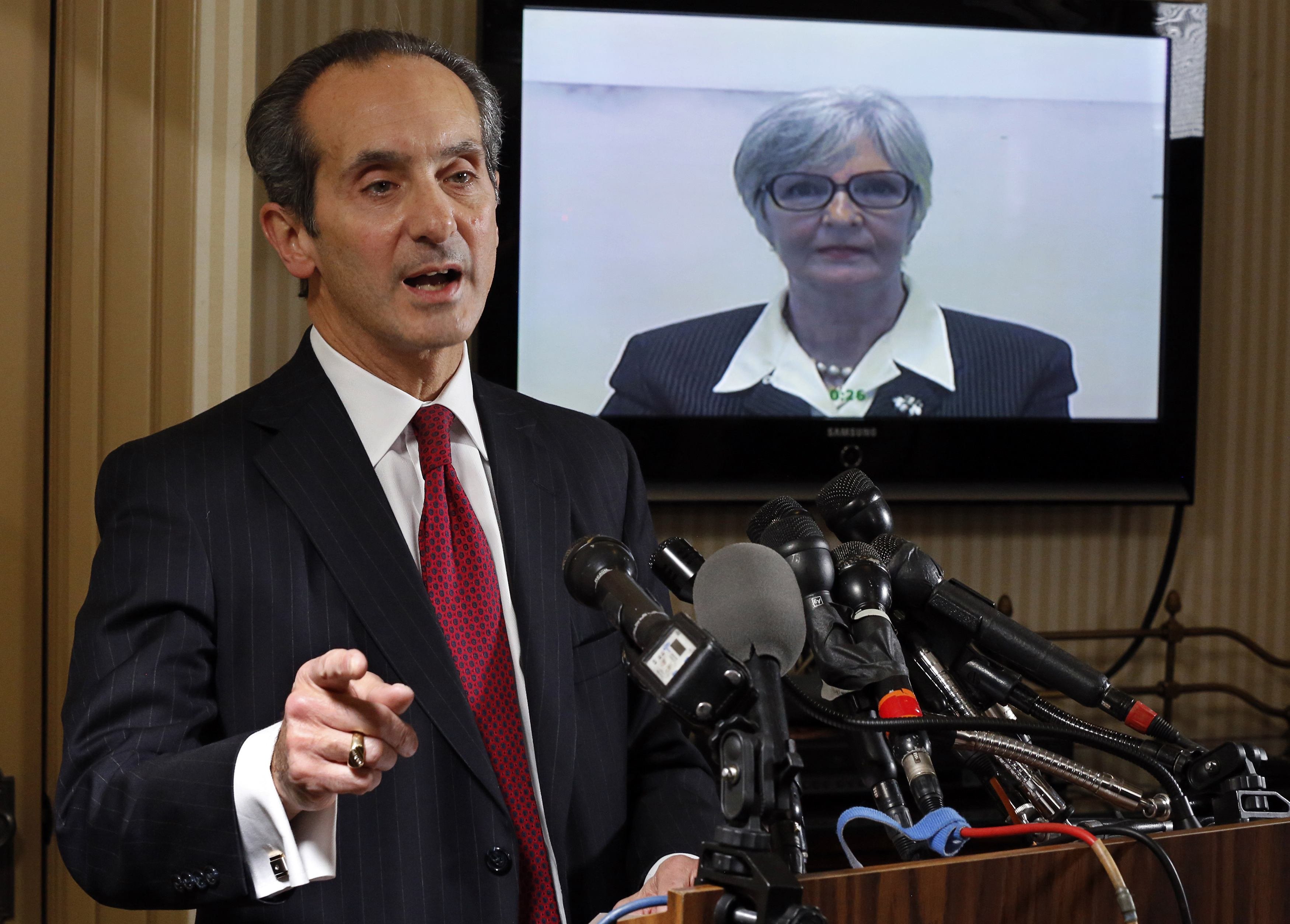 Tamara Green, the plaintiff in a defamation lawsuit claiming that she was "sexually assaulted by comedian Bill Cosby in the 1970s" watches by video link from California as her attorney Joseph Cammarata (L) speaks about the suit that they have filed to a 
