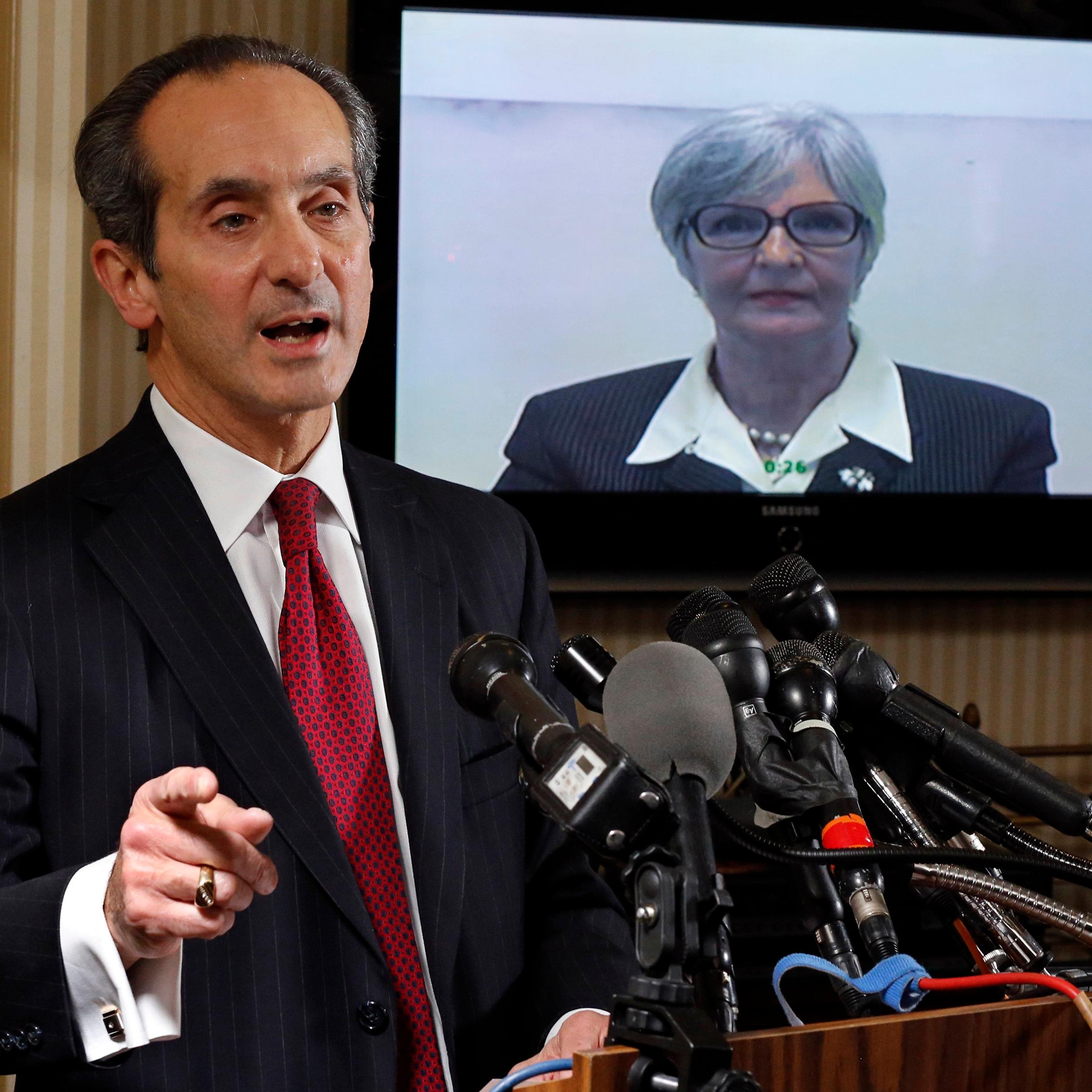 Tamara Green, the plaintiff in a defamation lawsuit claiming that she was "sexually assaulted by comedian Bill Cosby in the 1970s" watches by video link from California as her attorney Joseph Cammarata (L) speaks about the suit that they have filed to a