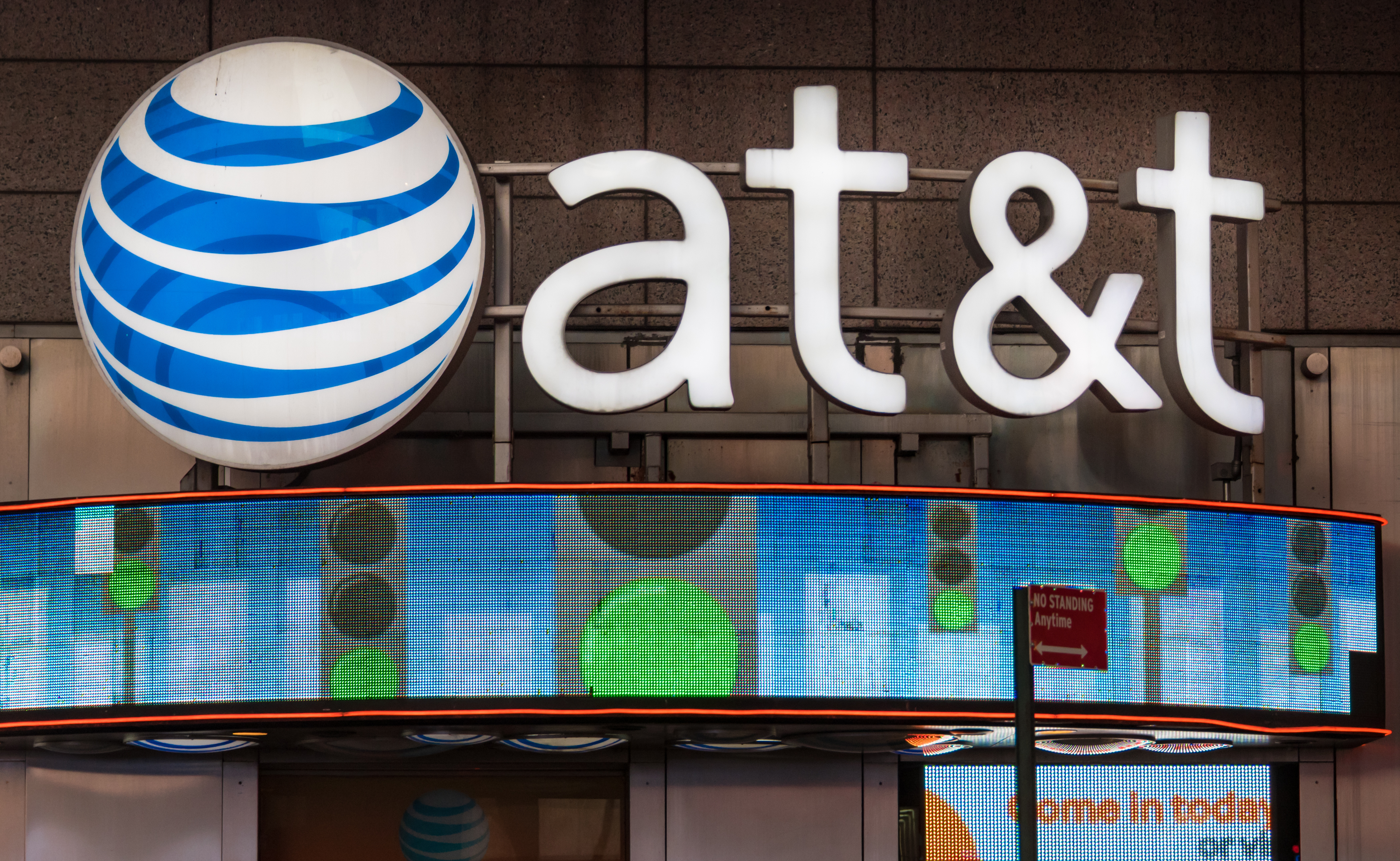AT&T office New York City, USA: Signage and logo outside its office glowing at night. AT&amp;T Inc. is an American multinational telecommunications corporation, headquartered at Whitacre Tower in downtown Dallas, Texas. (Photo by Roberto Machado Noa/Ligh