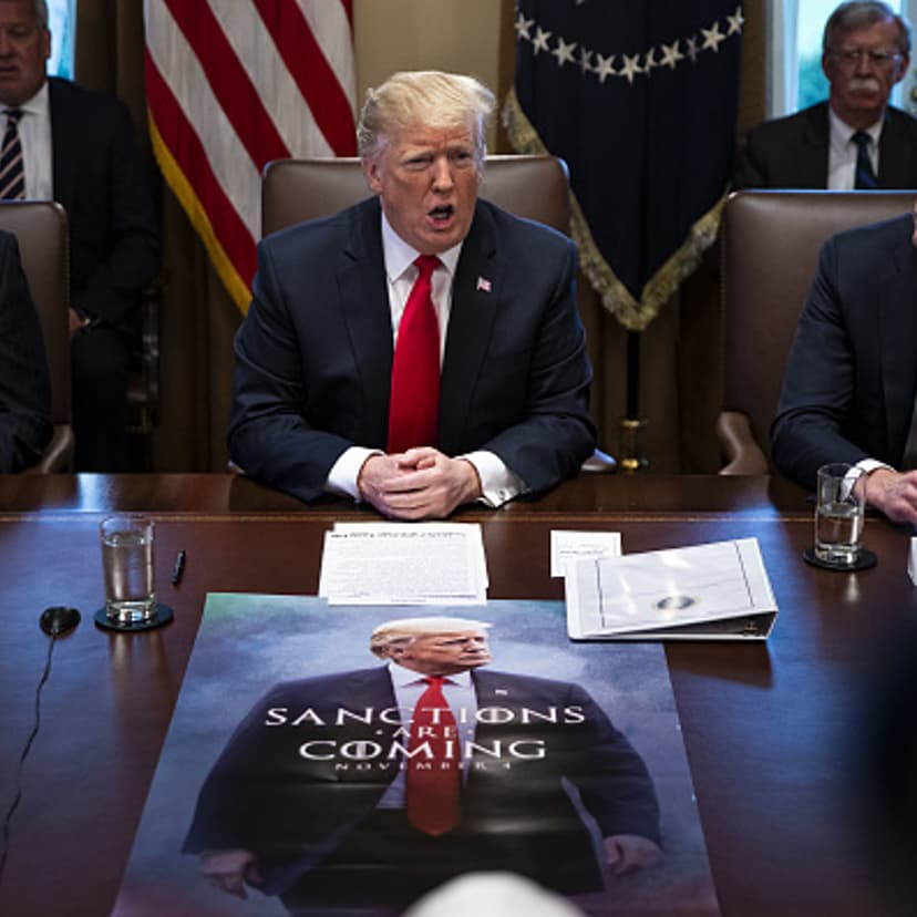 U.S. President Donald Trump, center, speaks in front of a poster that reads 'Sanctions Are Coming' during a meeting in the Cabinet Room of the White House in Washington, D.C., U.S., on on Wednesday, Jan. 2, 2019.