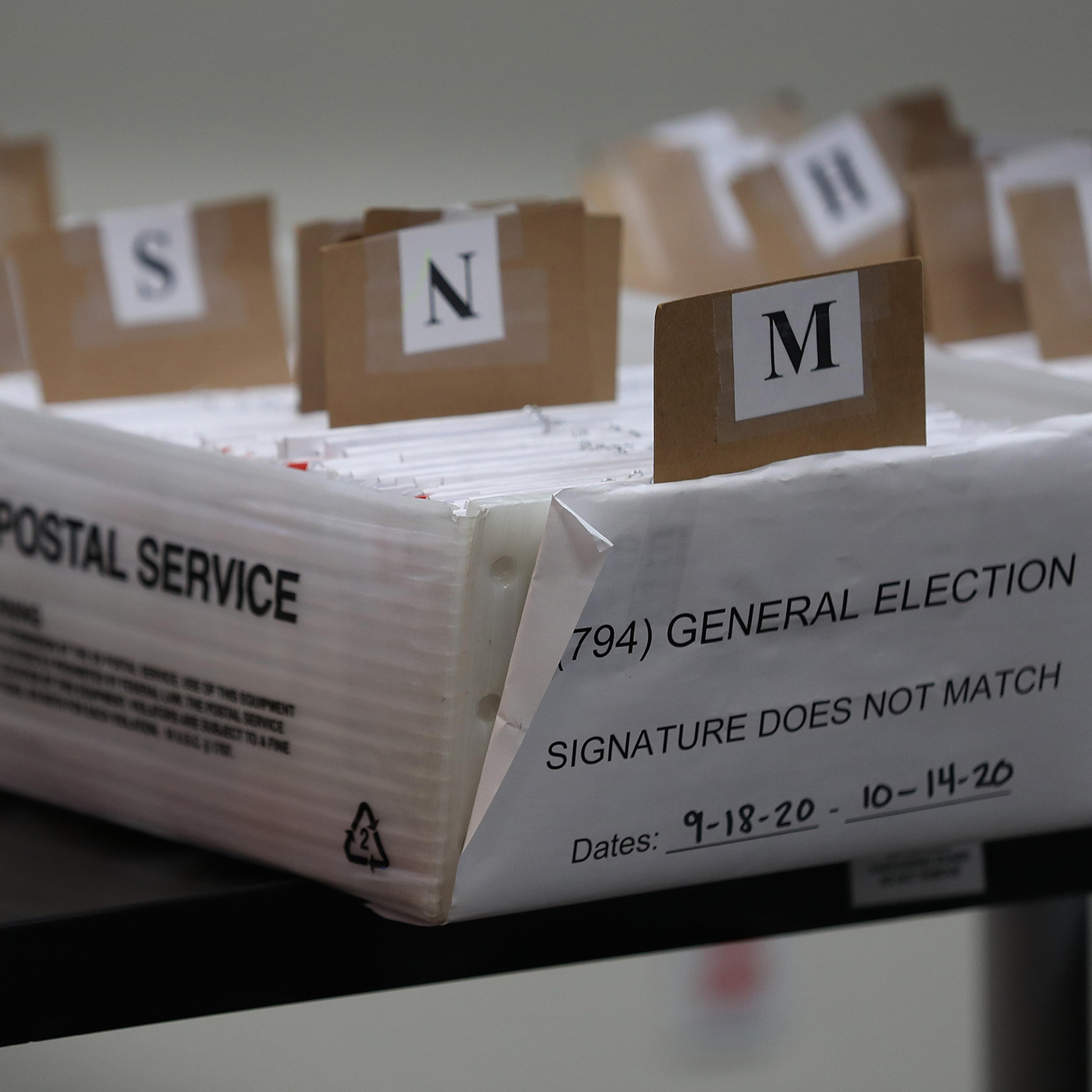 Boxes for Vote-by-Mail ballots that need to be reviewed due to signature discrepancies are seen ahead of the Nov. 3rd general election at the Miami-Dade County Elections Department on Oct. 15 in Doral, Florida