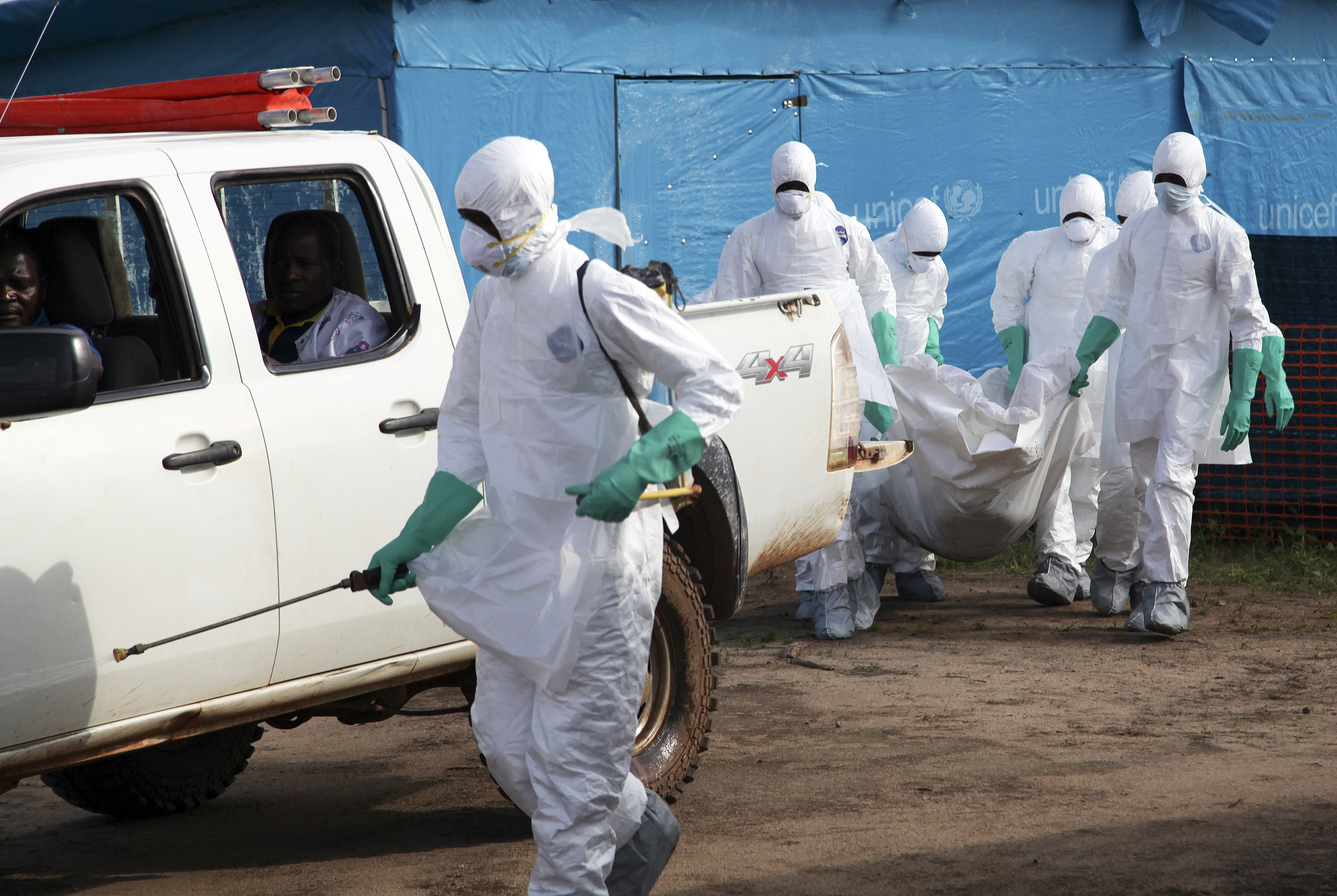 Liberian health workers in protective gear on the way to bury a woman who died of the Ebola virus from the isolation unit in Foya, Lofa County, Liberia on July 2, 2014.