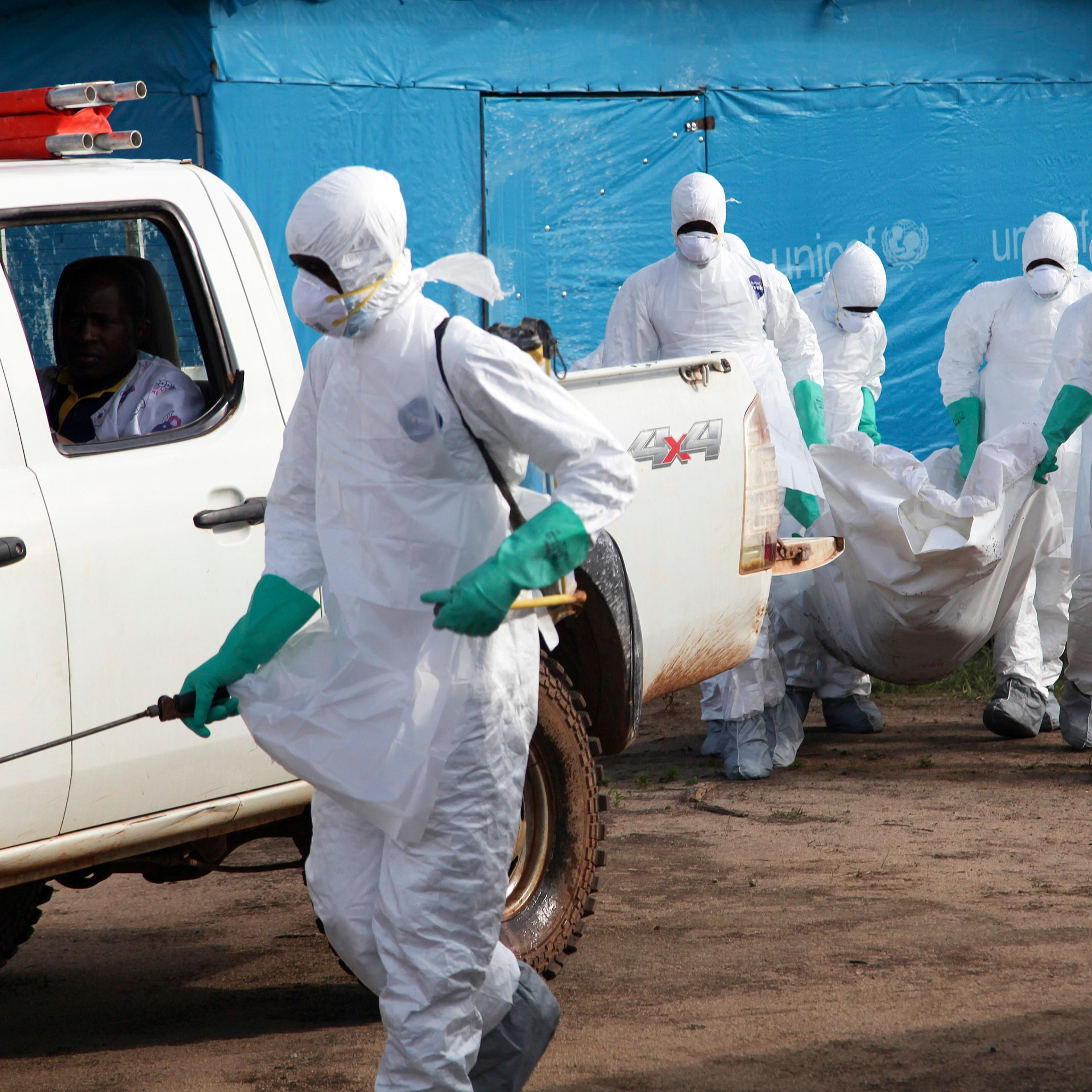 Liberian health workers in protective gear on the way to bury a woman who died of the Ebola virus from the isolation unit in Foya, Lofa County, Liberia on July 2, 2014.
