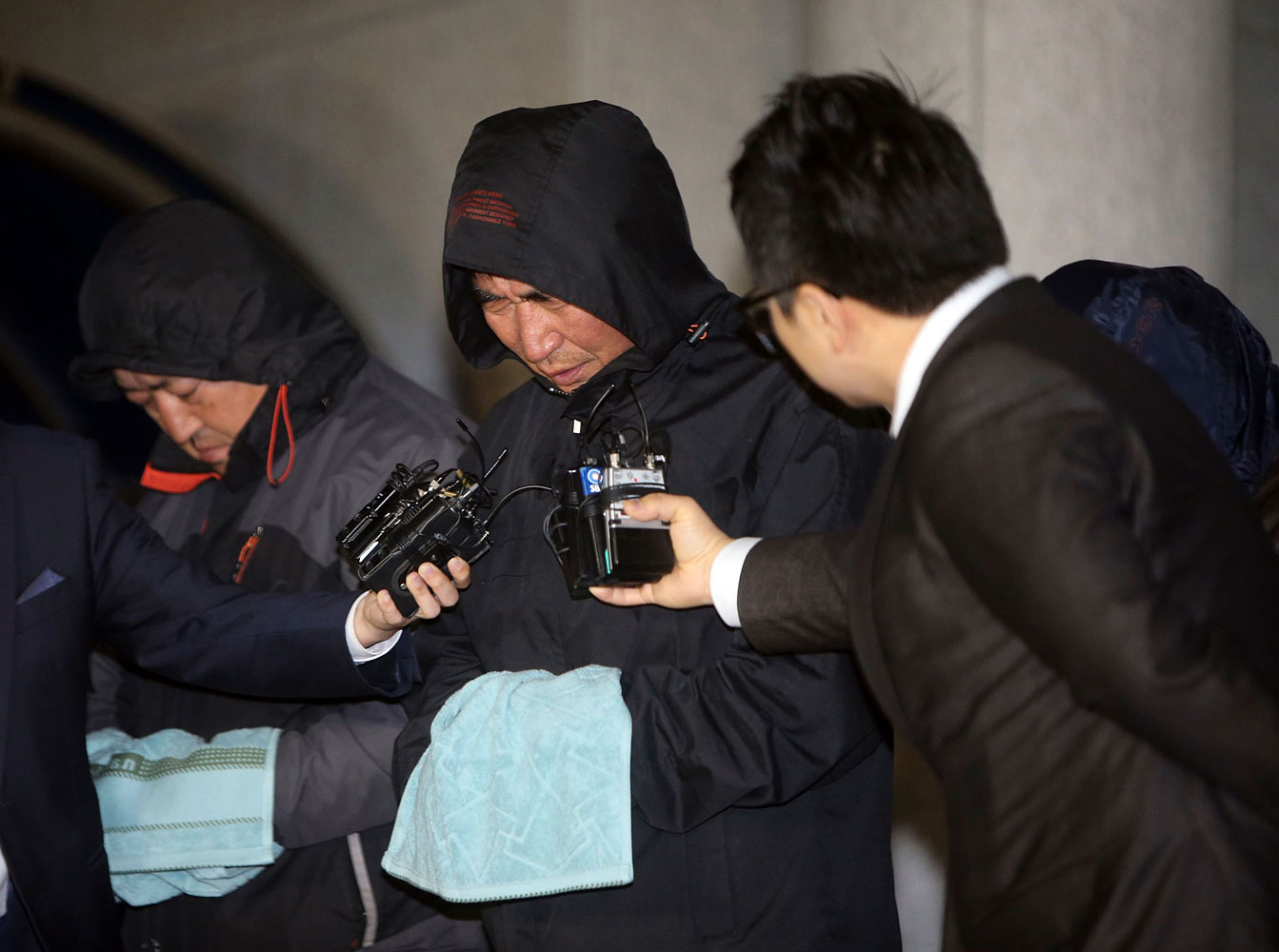 Journalists ask Lee Joon-seok, captain of South Korean ferry Sewol which sank at sea off Jindo, questions as Lee walked out of court after an investigation in Mokpo April 19, 2014.