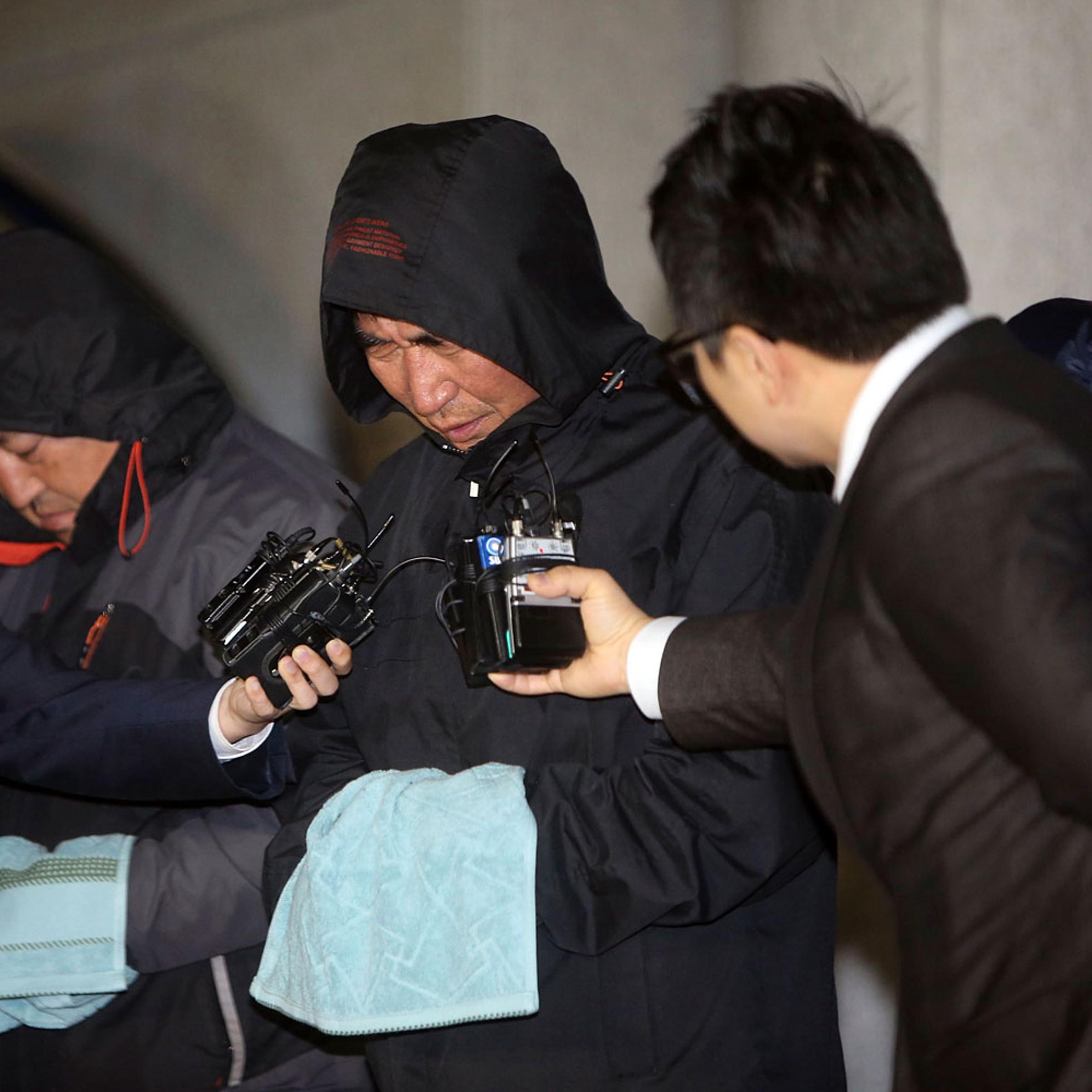 Journalists ask Lee Joon-seok, captain of South Korean ferry Sewol which sank at sea off Jindo, questions as Lee walked out of court after an investigation in Mokpo April 19, 2014.