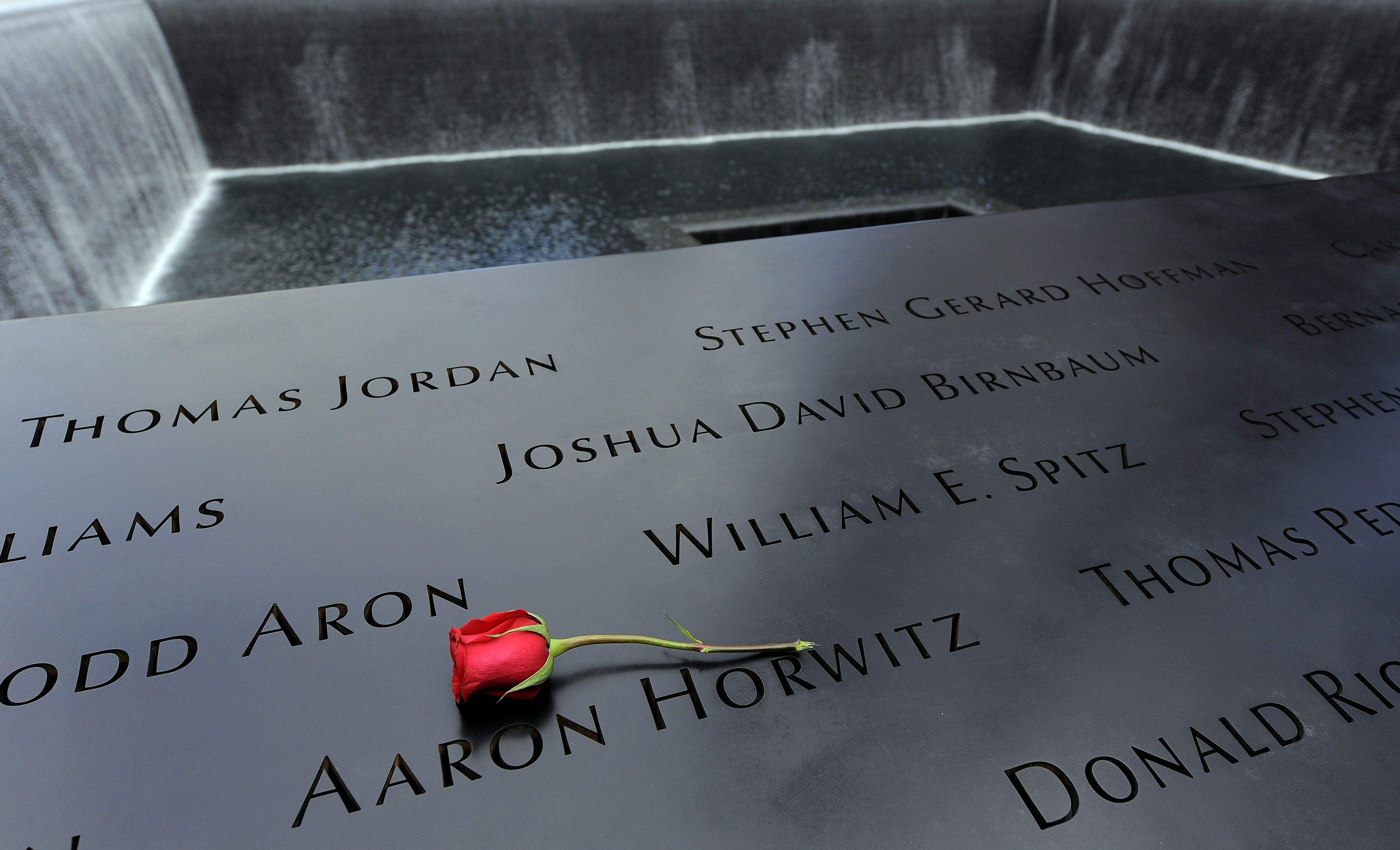 A rose is placed on the names inscribed around the North Pool of the 9/11 Memorial during tenth anniversary ceremonies at the site of the World Trade Center in New York on Sept. 11, 2011.