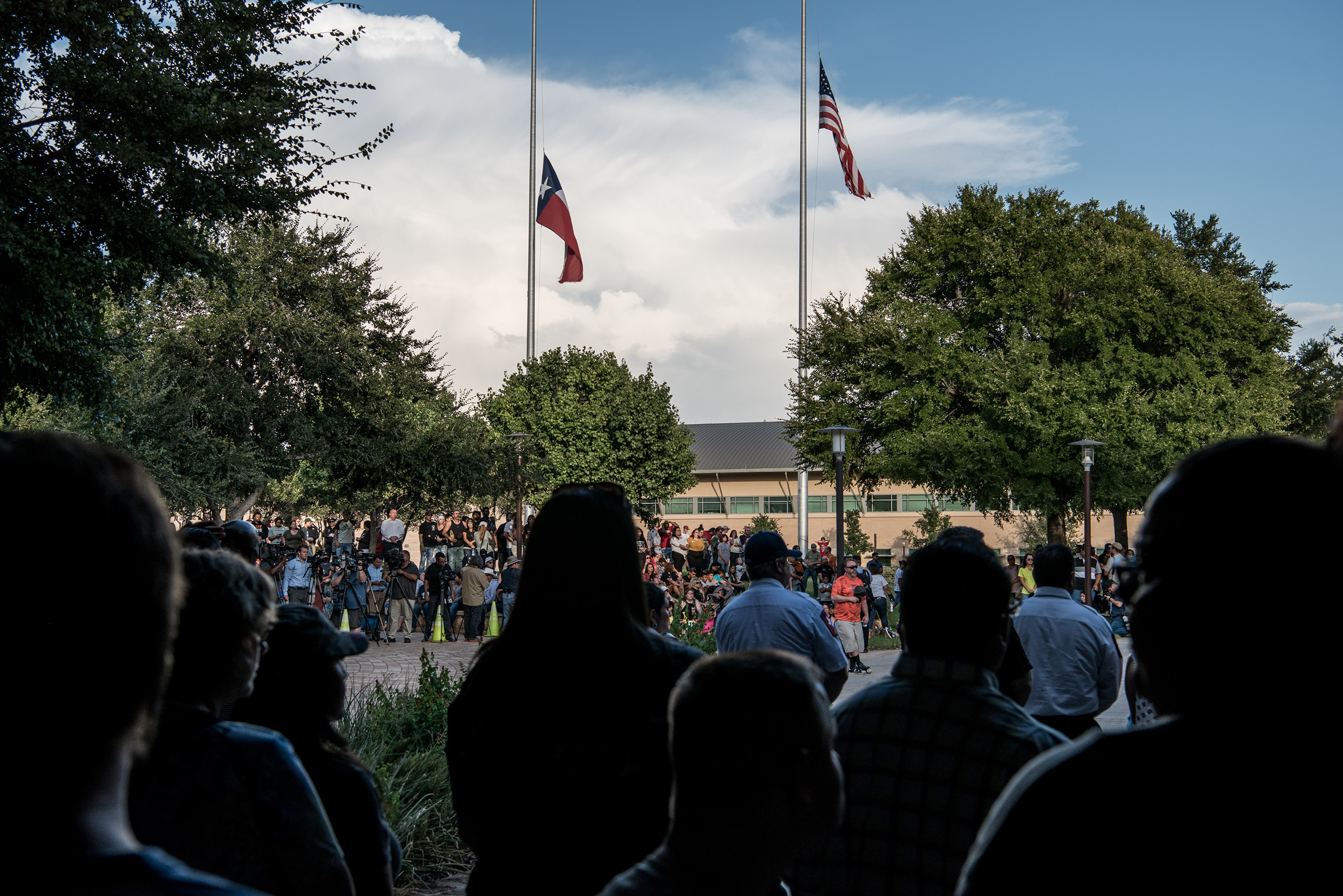 Flags fly at half mast over a prayer vigil at the University of Texas of the Permian Basin