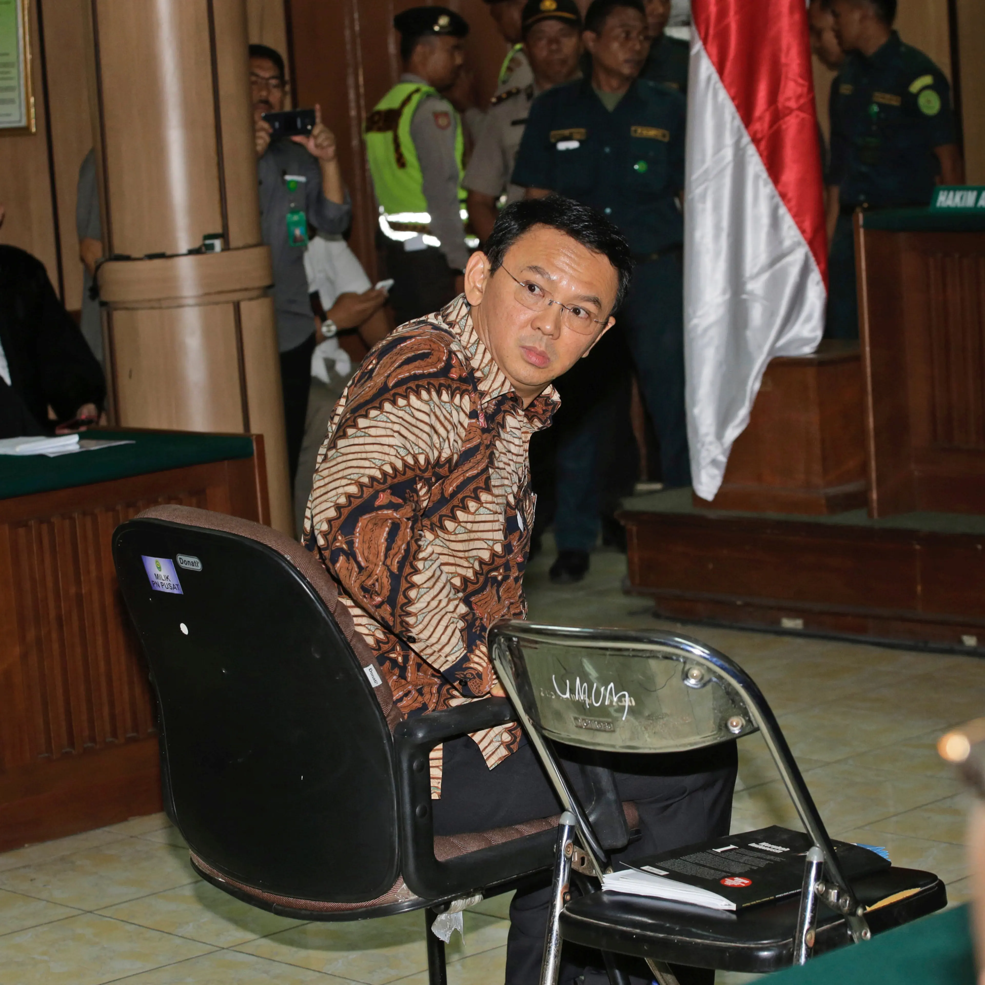 Jakarta Governor Basuki Tjahaja Purnama, popularly known as "Ahok", sits on the defendant's chair at the start of his trial hearing at North Jakarta District Court in Jakarta