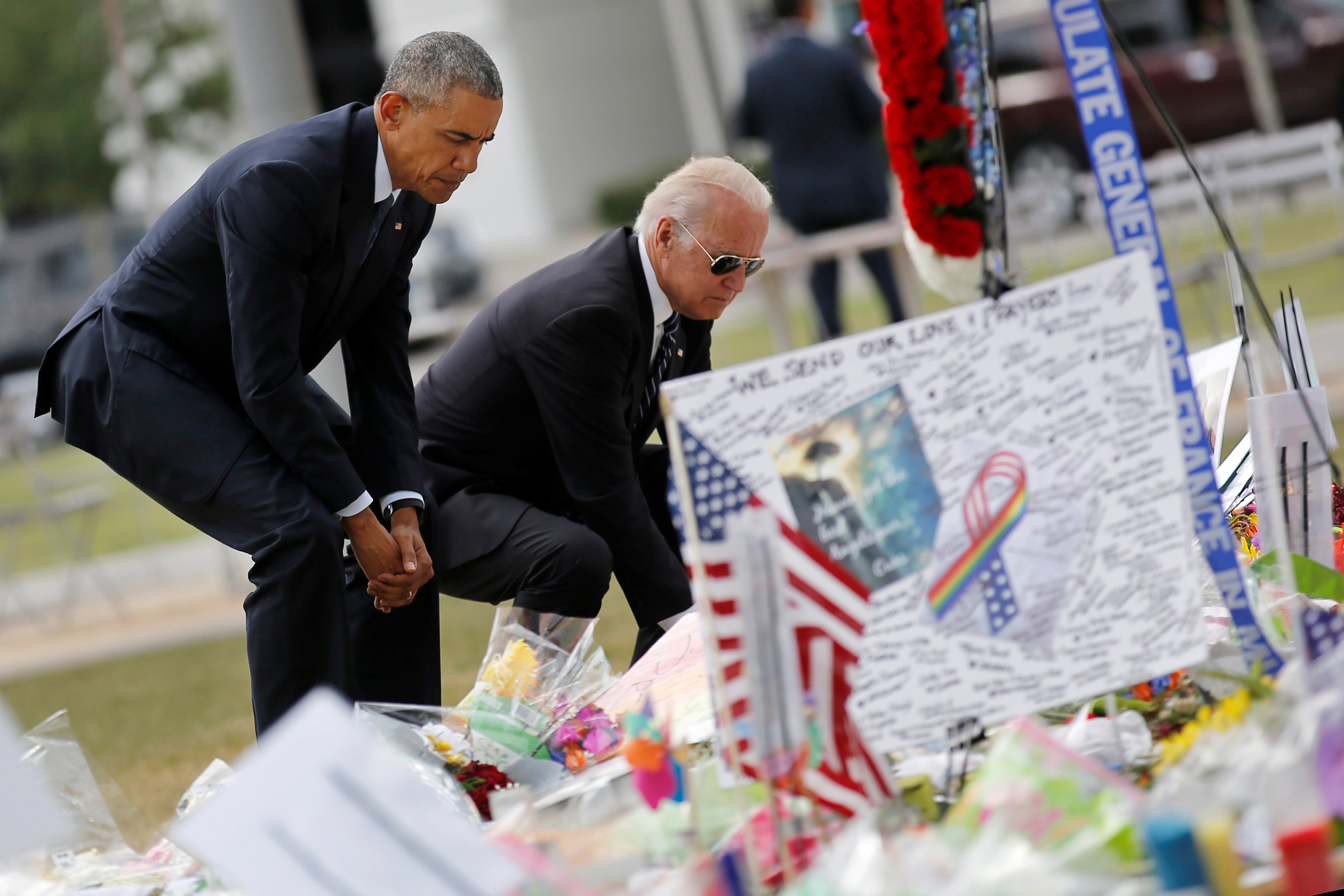 U.S. President Barack Obama (L) and Vice President Joe Biden pause as they place flowers at a makeshift memorial for shooting victims of the massacre at a gay nightclub in Orlando, Florida, U.S., June 16, 2016. REUTERS/Carlos Barria