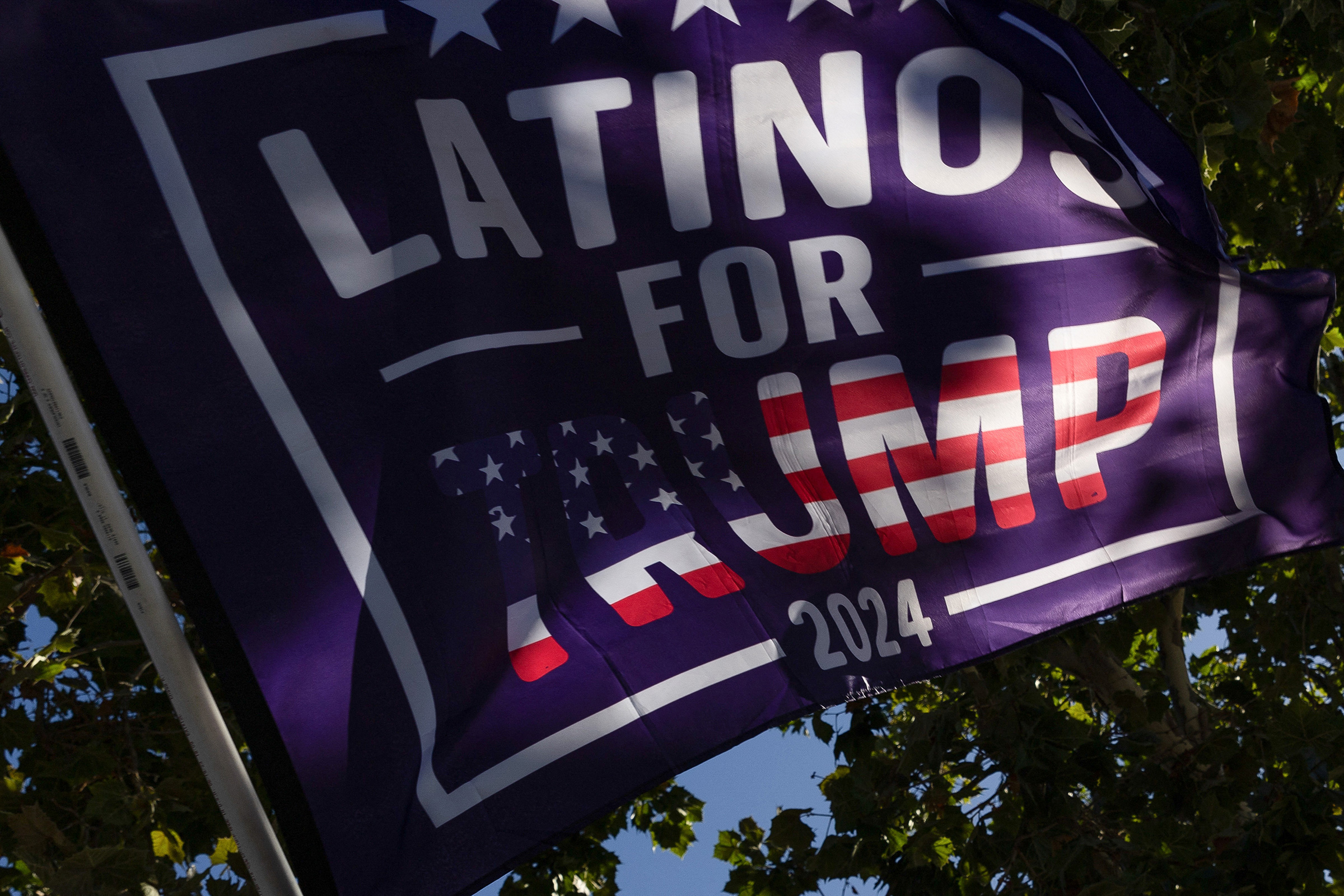 Supporters of Donald Trump hold a 'Latinos for Trump' flag before a fundraiser in Palo Alto, Calif., Sept. 13, 2024.