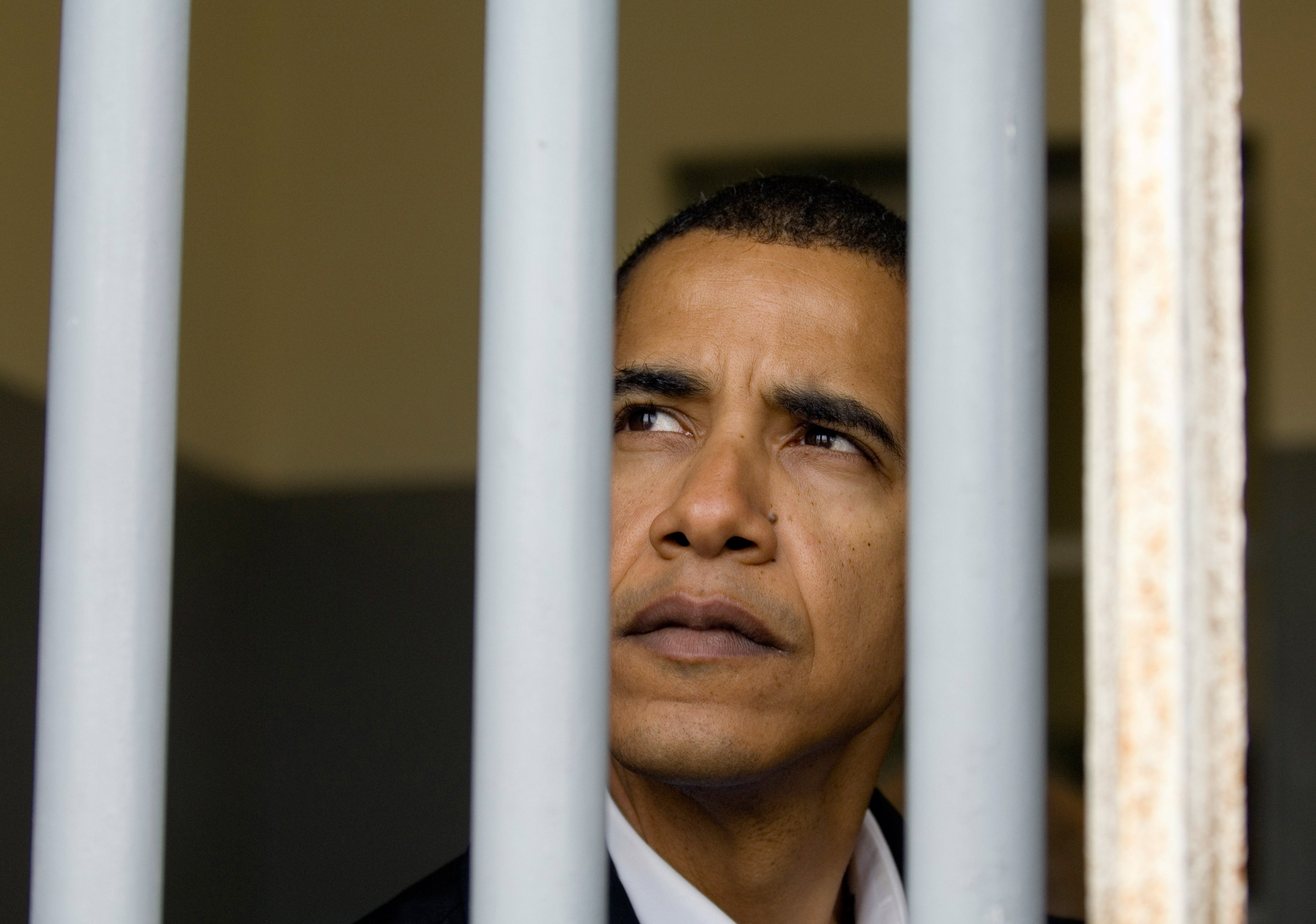 Barack Obama pictured when he was a U.S. Senator (D-Ill.) sitting in Nelson Mandela's prison cell on Robben Island off the coast of Cape Town, South Africa, on Aug. 20, 2006.