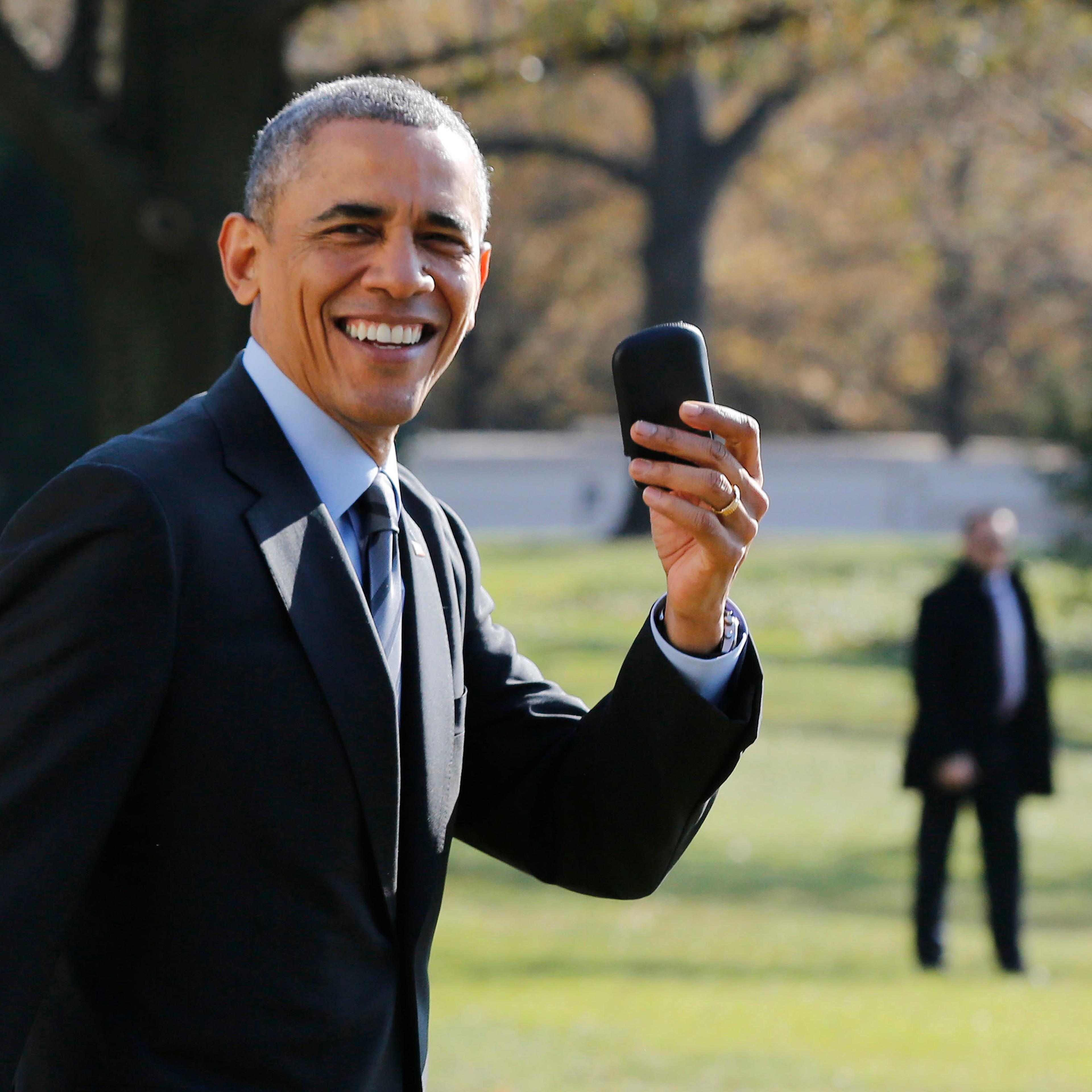 U.S. President Barack Obama holds up his BlackBerry device after he returned inside the White House to retrieve it, after boarding Marine One on the South Lawn of the White House in Washington on Nov. 21, 2014.