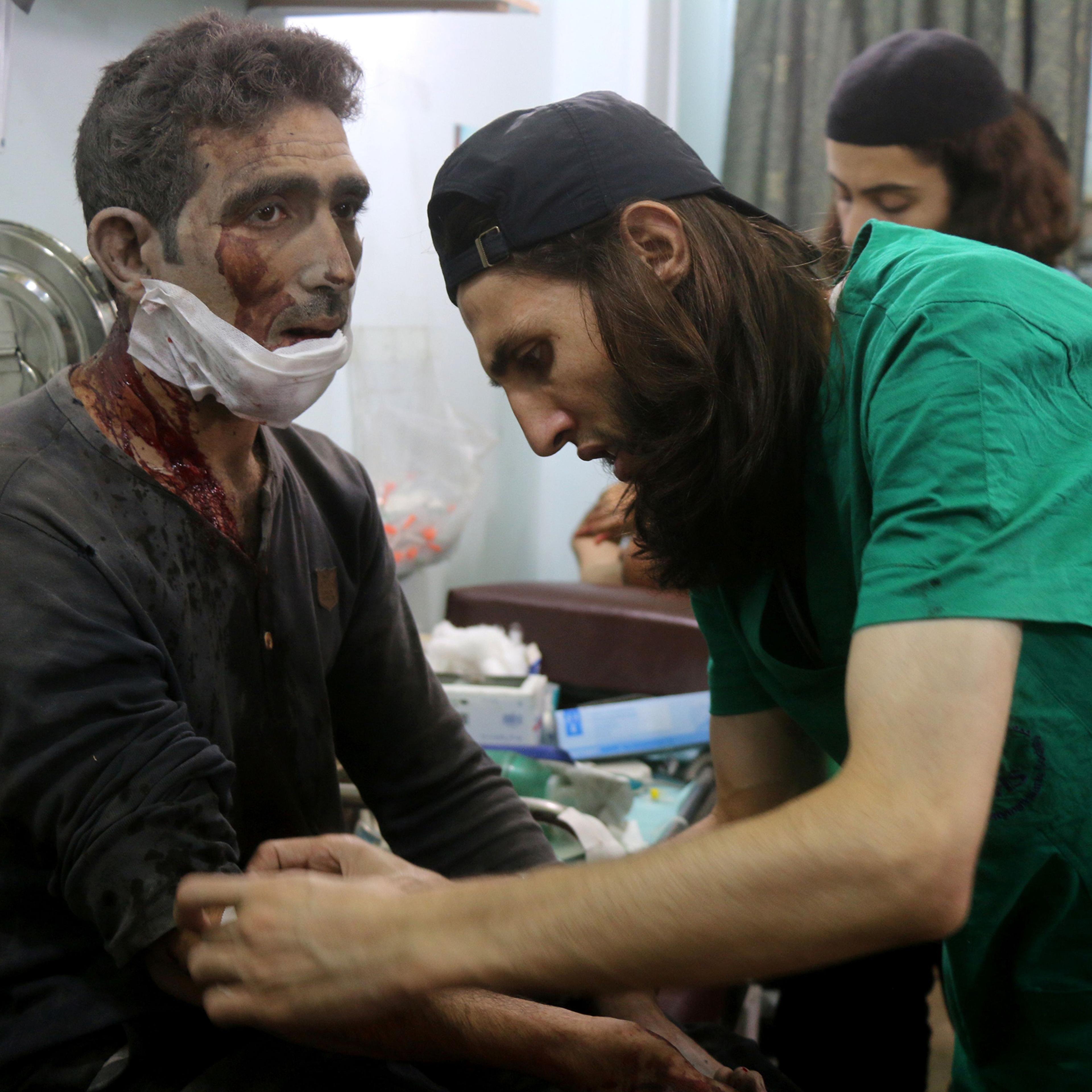 Syrian medics treat a man at a makeshift hospital in the Tariq al-Bab neighborhood of Aleppo after he was wounded during reported air raids that targeted rebel-held areas on Aug. 16, 2016.