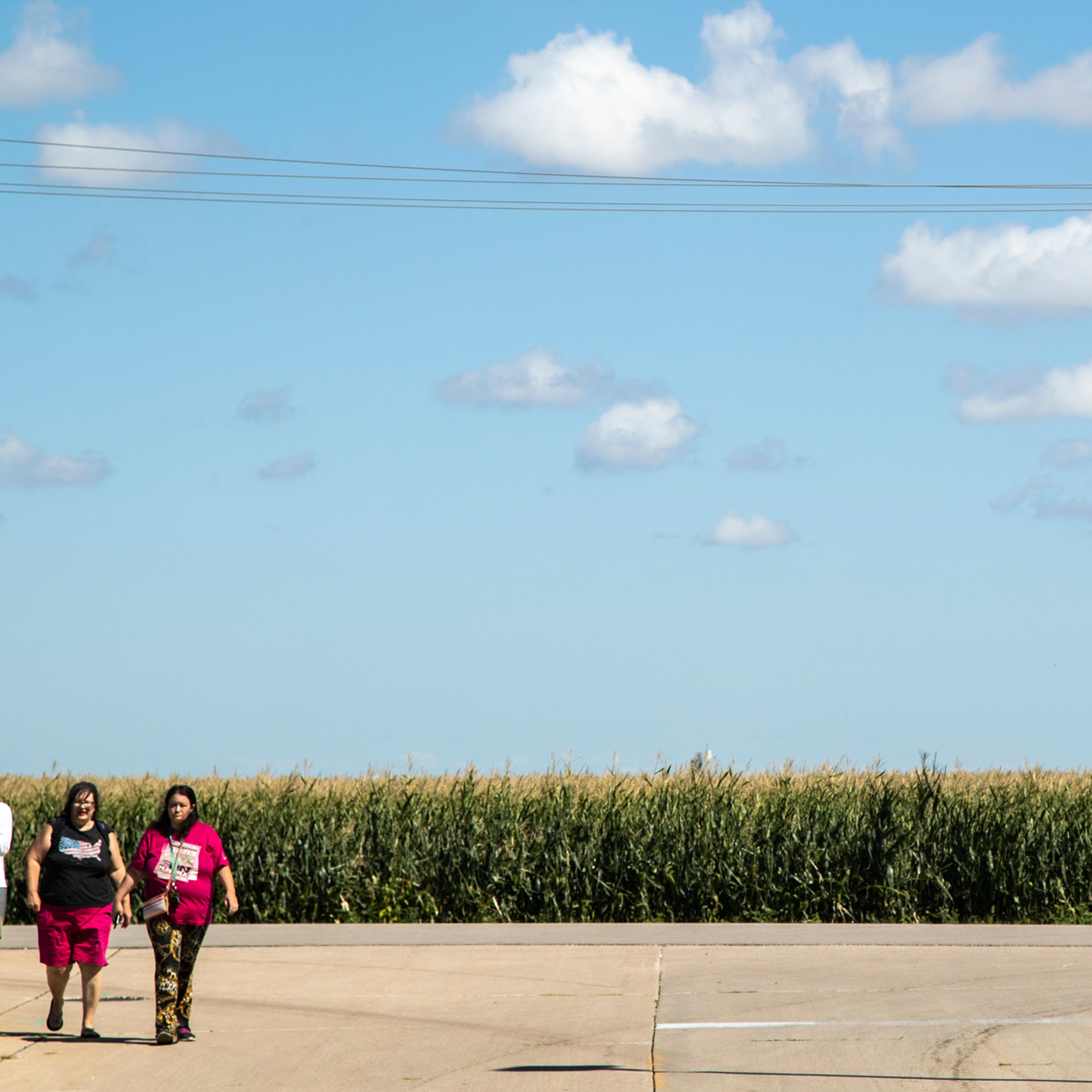 People arrive to watch Air Force One land, on Aug. 18, 2020, as President Donald Trump visits with Iowa leaders after a derecho on Aug. 10, in Cedar Rapids, Iowa.
