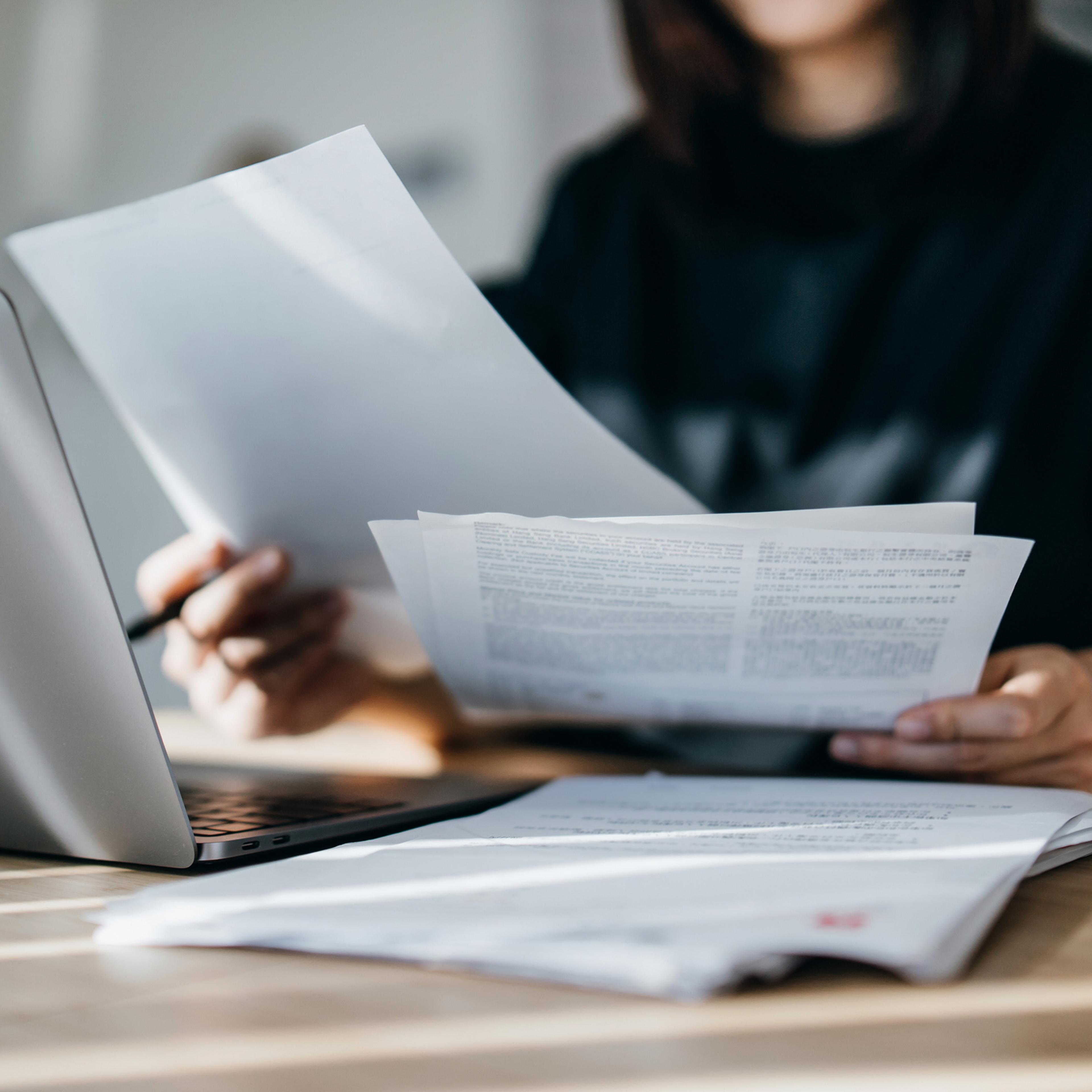 Cropped shot of young Asian woman handling personal banking and finance with laptop at home. Planning budget and calculating expenses. Managing taxes and financial bills. Wealth management. Digital banking habits. Smart banking with technology