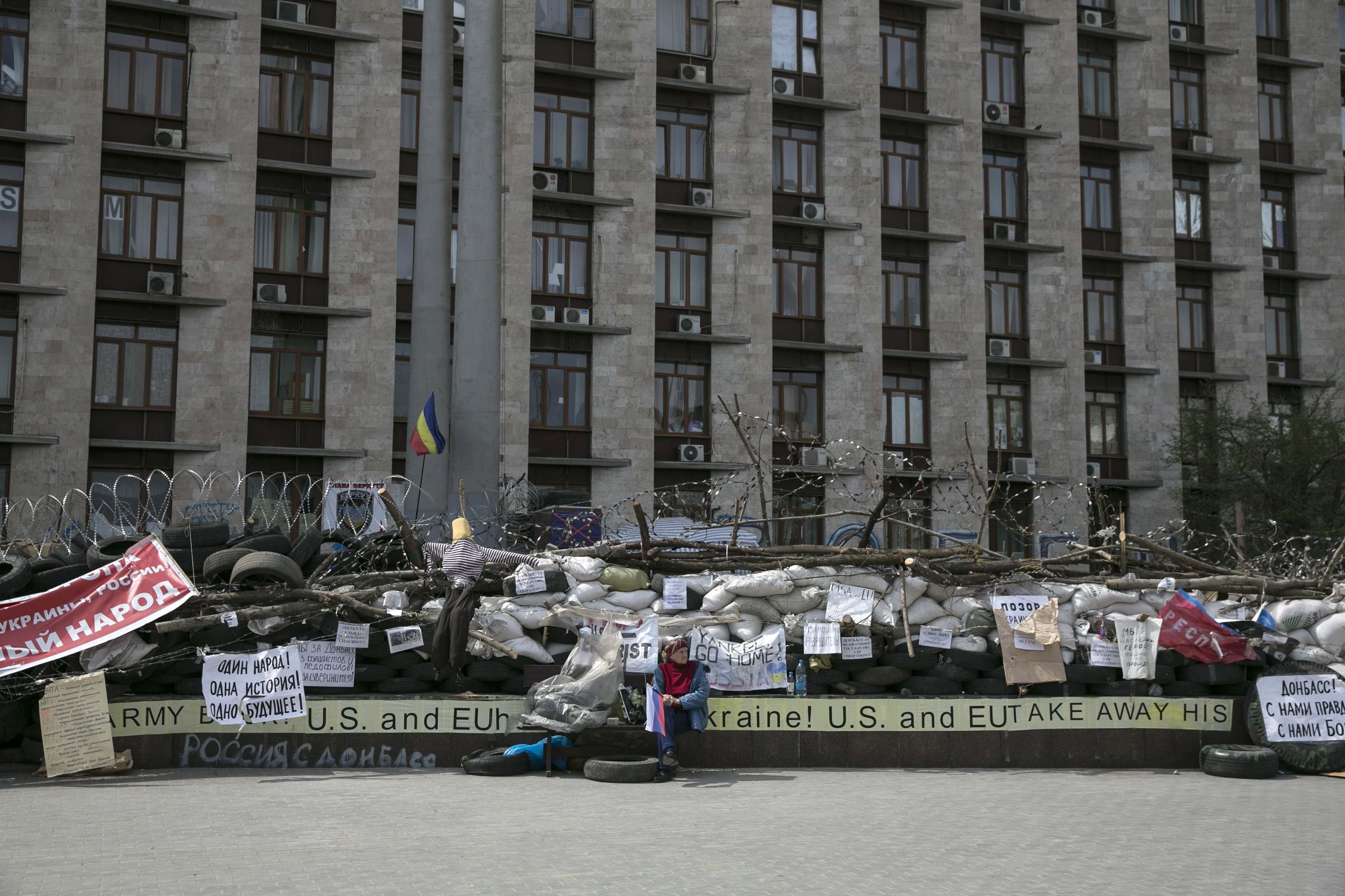 A pro-Russia woman holds a Russian flag outside a regional government building in Donetsk