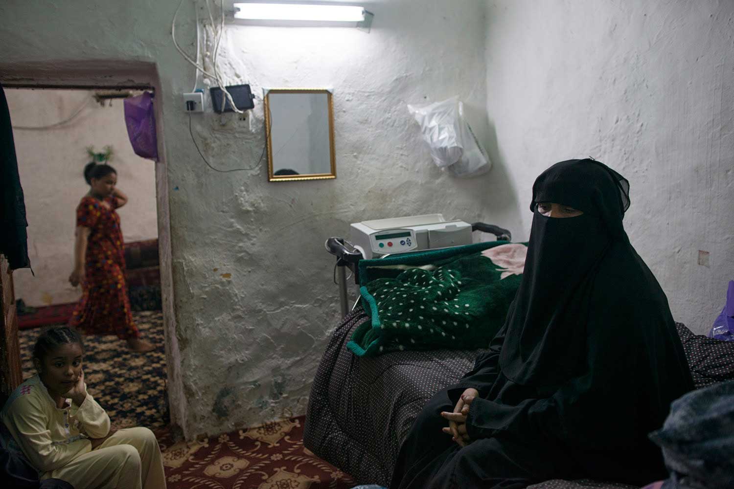 Fatima Hazazi stands in front of boxes of medicine she requires monthly to treat her kidney problem at home in Riyadh, Saudi Arabia, March 2, 2013.   Like many families across Saudi Arabia who are barely scraping above the poverty line each month, Fatima