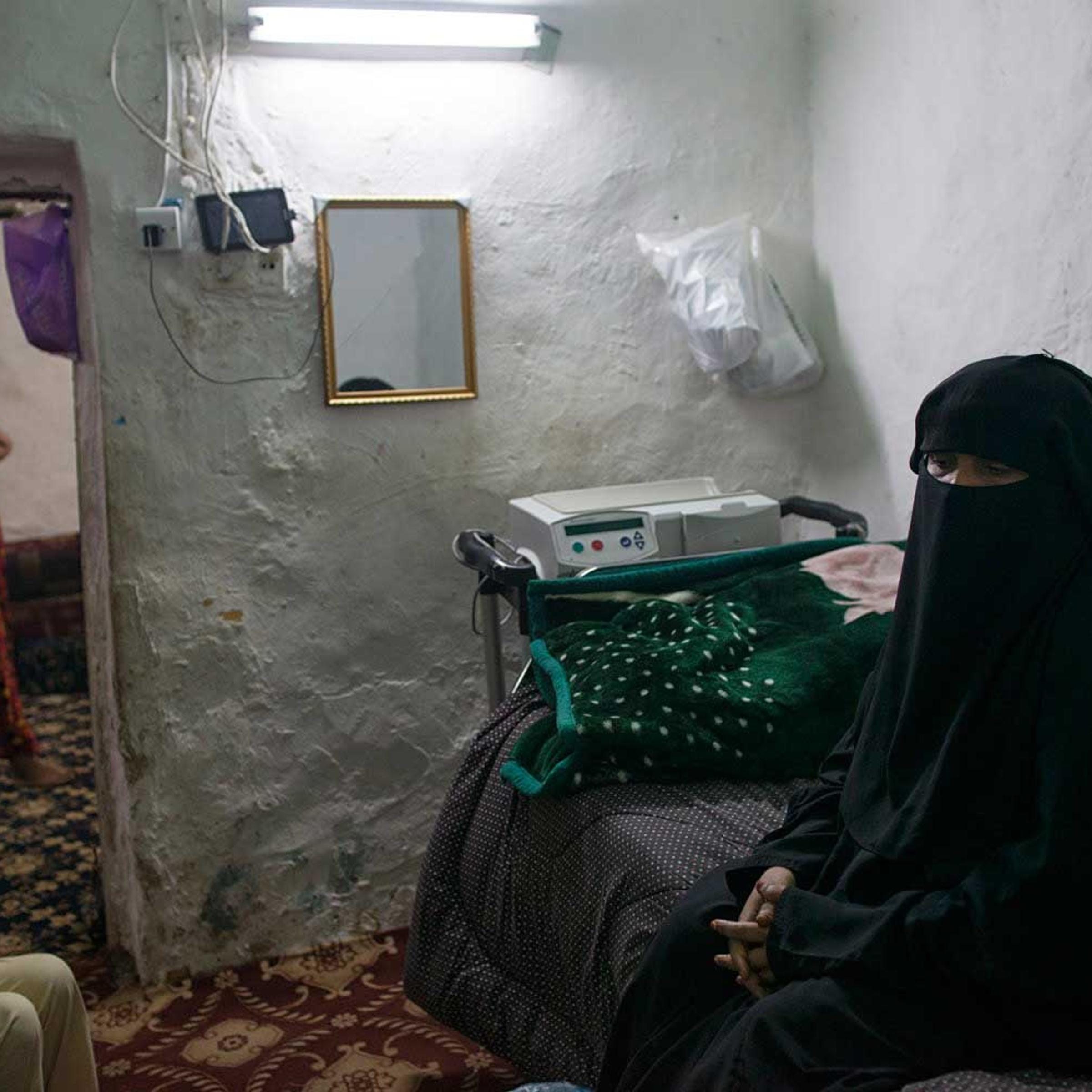 Fatima Hazazi stands in front of boxes of medicine she requires monthly to treat her kidney problem at home in Riyadh, Saudi Arabia, March 2, 2013. Like many families across Saudi Arabia who are barely scraping above the poverty line each month, Fatima