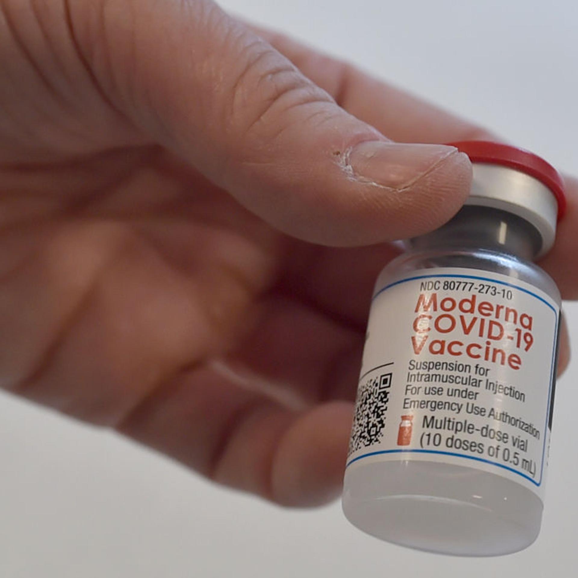 A health workers holds a vial of containing Moderna Covid-19