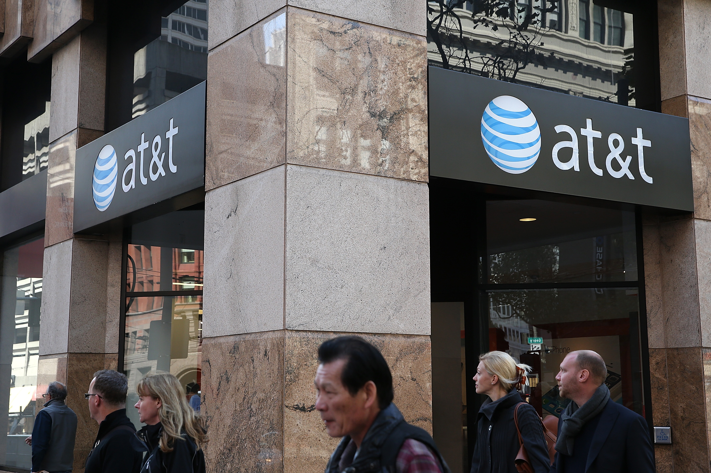 Pedestrians walk by an AT&T store on Oct. 23, 2013 in San Francisco.