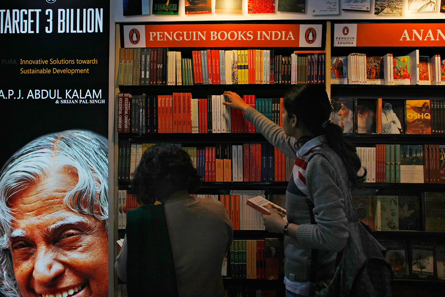 Indian women browse through Penguin edition books on display at the New Delhi World Book Fair in New Delhi in 2012
