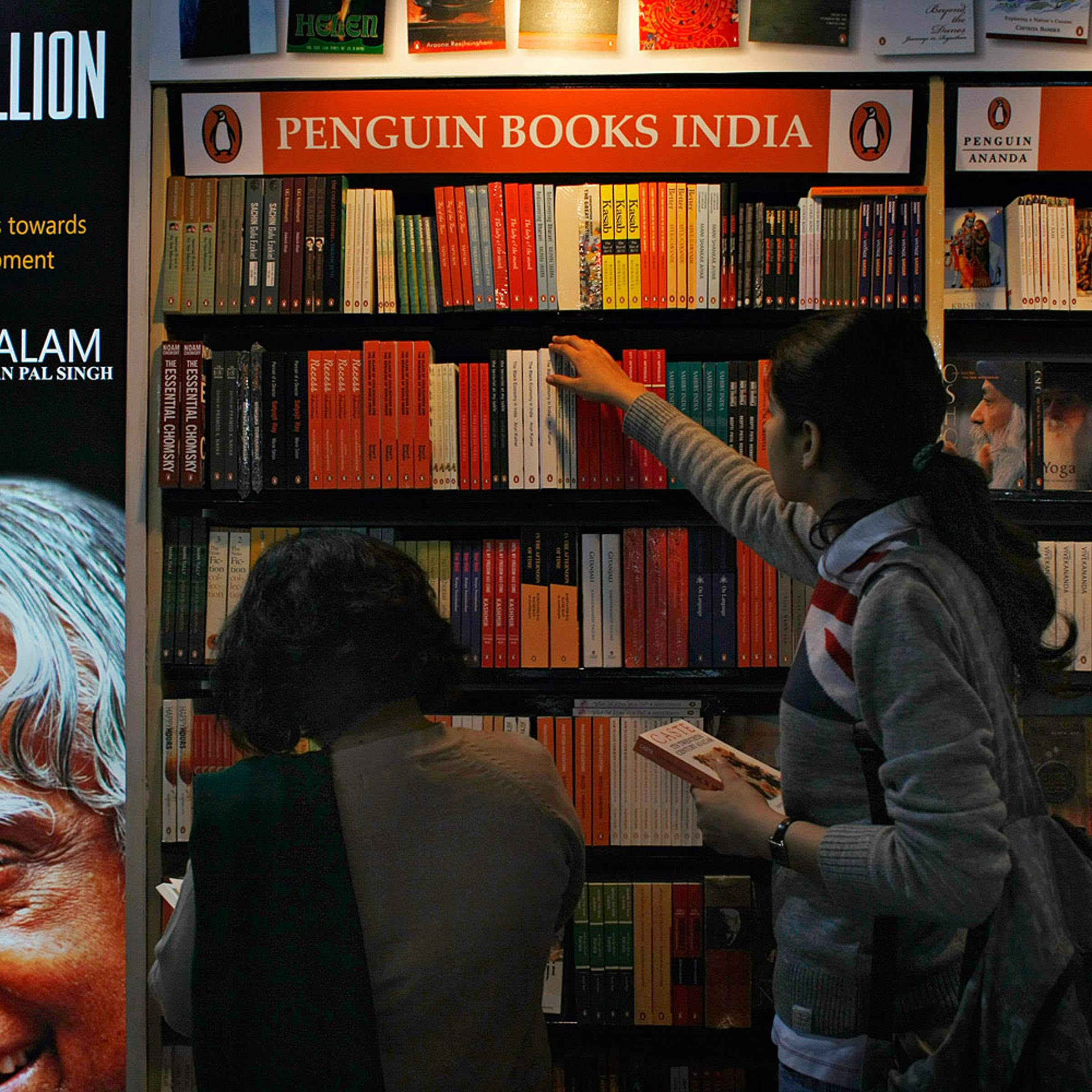 Indian women browse through Penguin edition books on display at the New Delhi World Book Fair in New Delhi in 2012
