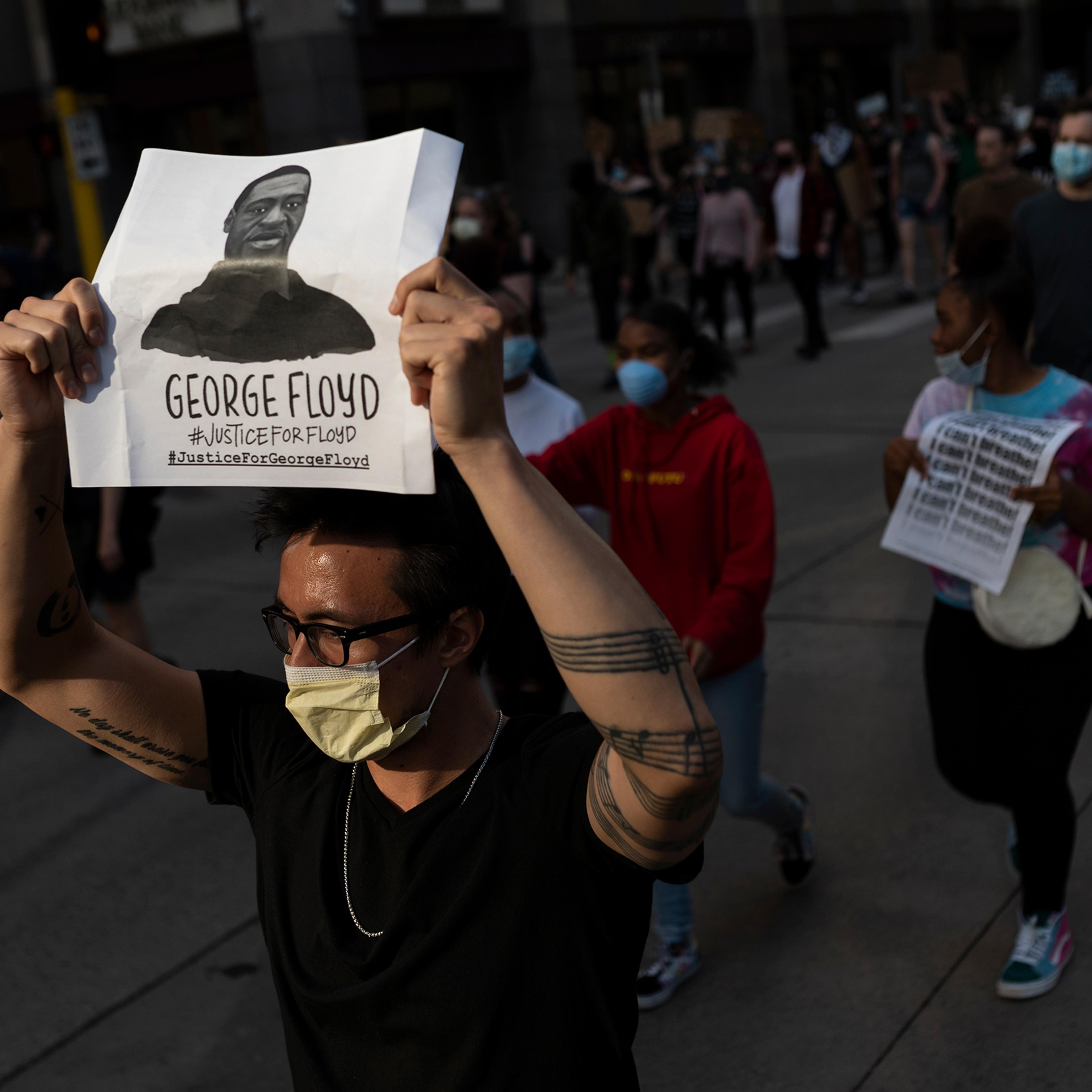 Protesters march through the street on May 28 in downtown Minneapolis. Police and protesters continued to clash for a third night after George Floyd was killed in police custody on Monday