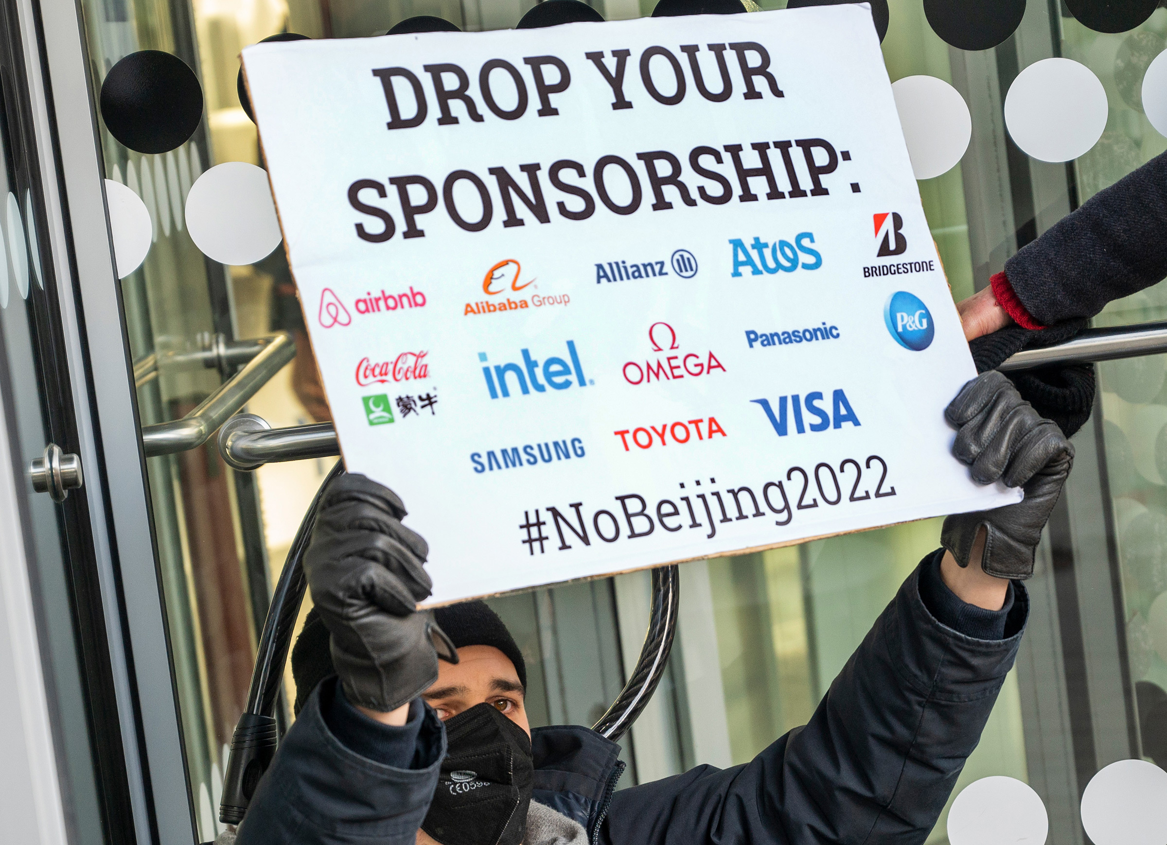 An activist protests in front of an Allianz Insurance branch in Berlin on Jan. 21, 2022.