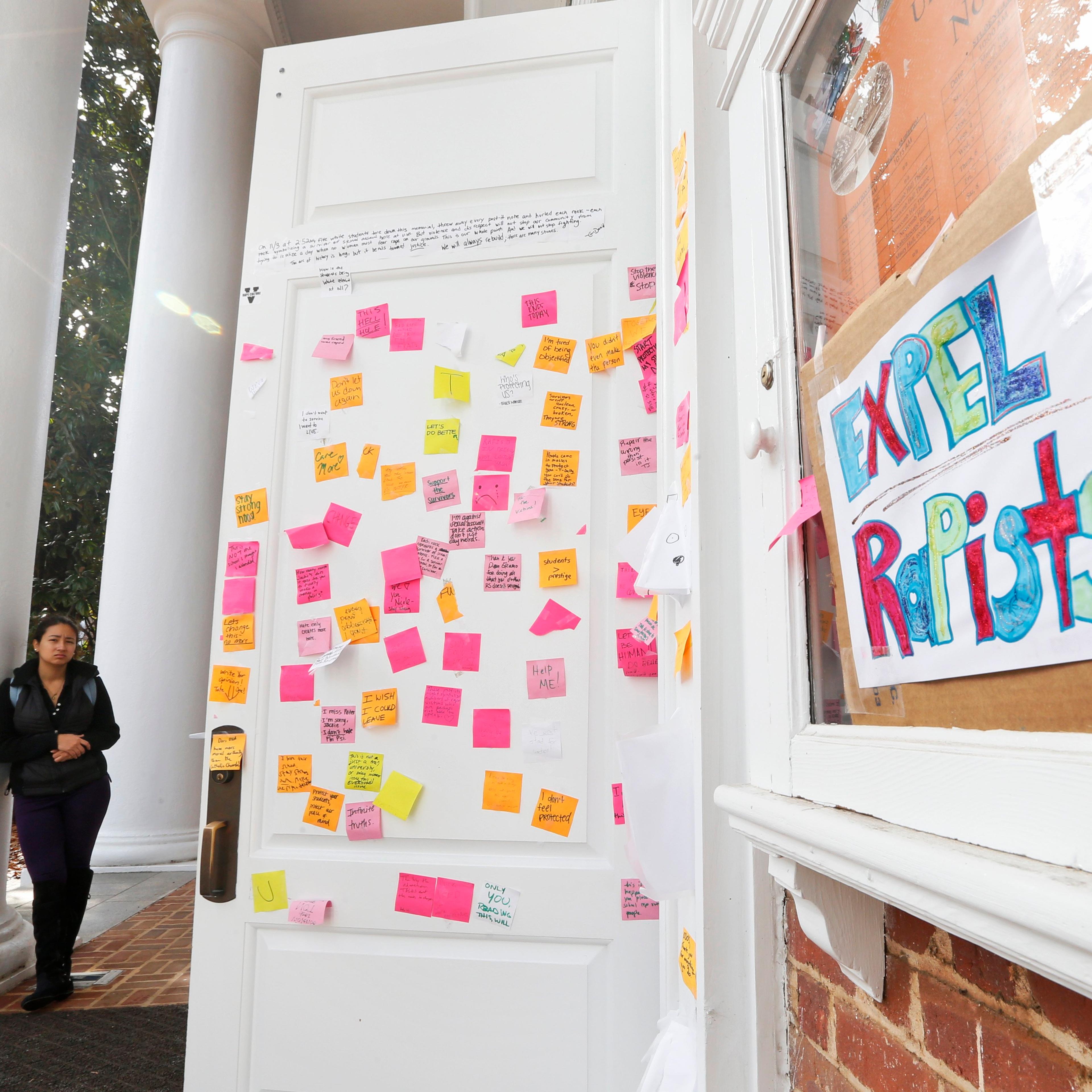 A University of Virginia student looks over postings on the door of Peabody Hall related to the Phi Kappa Psi gang rape allegations at the school in Charlottesville, Va. on Nov. 24, 2014.