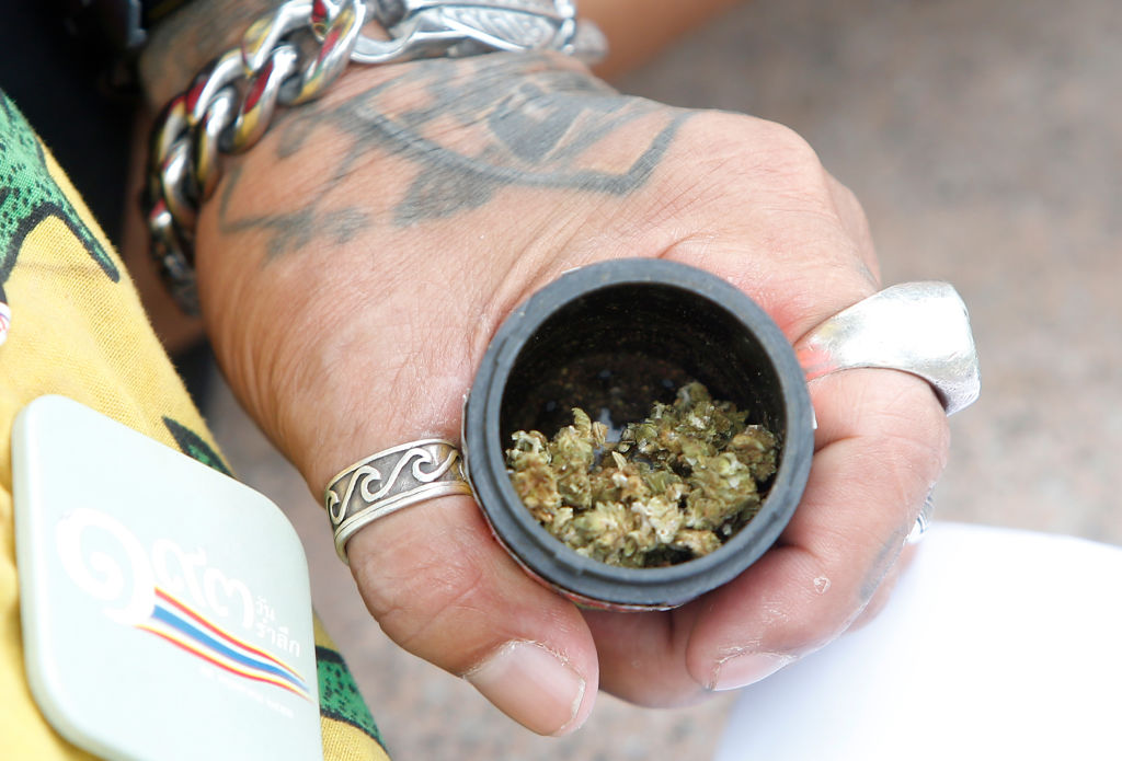 A man holding a box of cannabis buds during a protest outside the United Nation building in Bangkok on June 9, 2024.