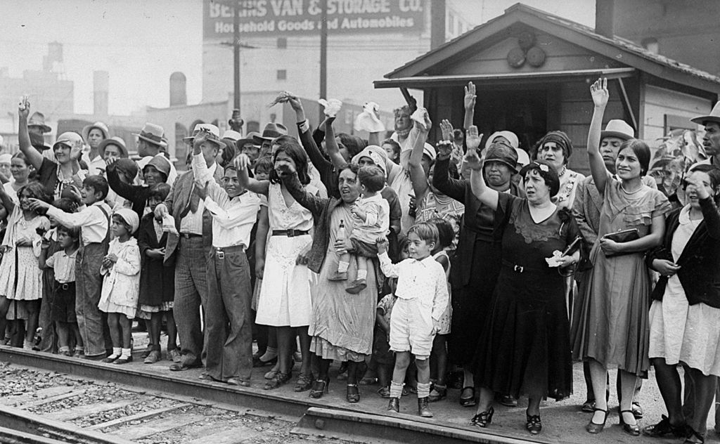 Relatives and friends wave goodbye to a train carrying 1,500