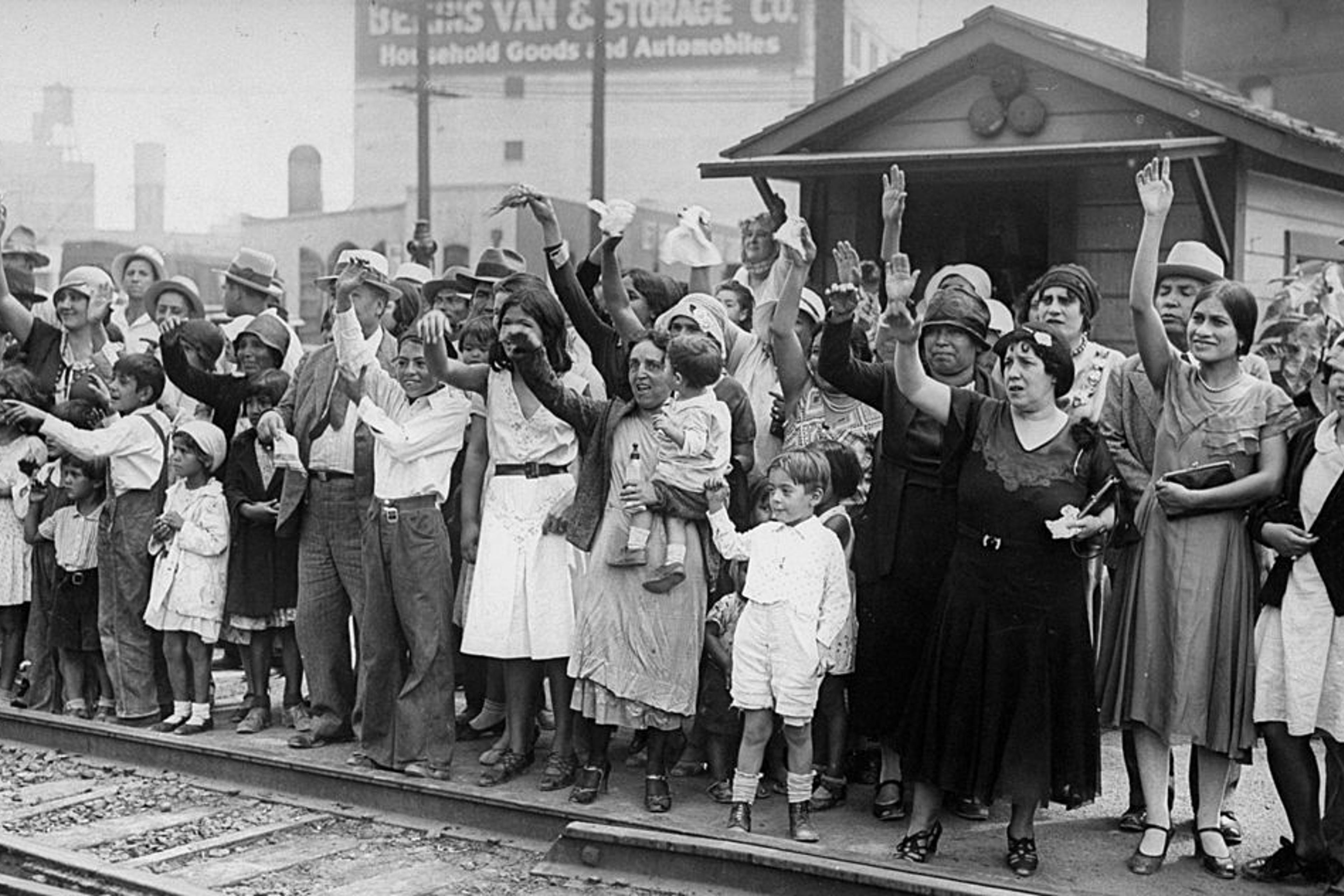 Relatives and friends wave goodbye to a train carrying 1,500