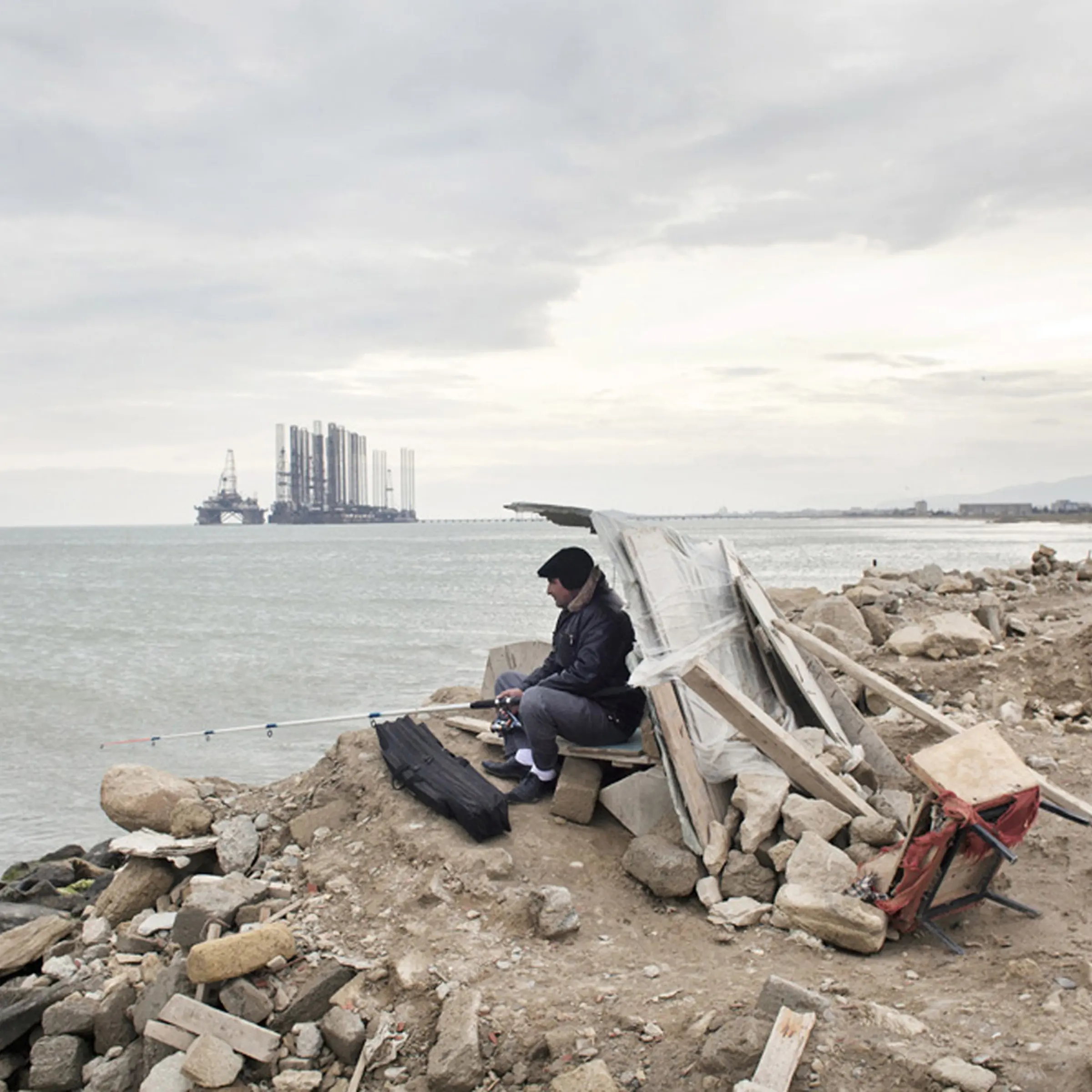A man fishes at Sahil beach near Baku, Azerbaijan, 2010.