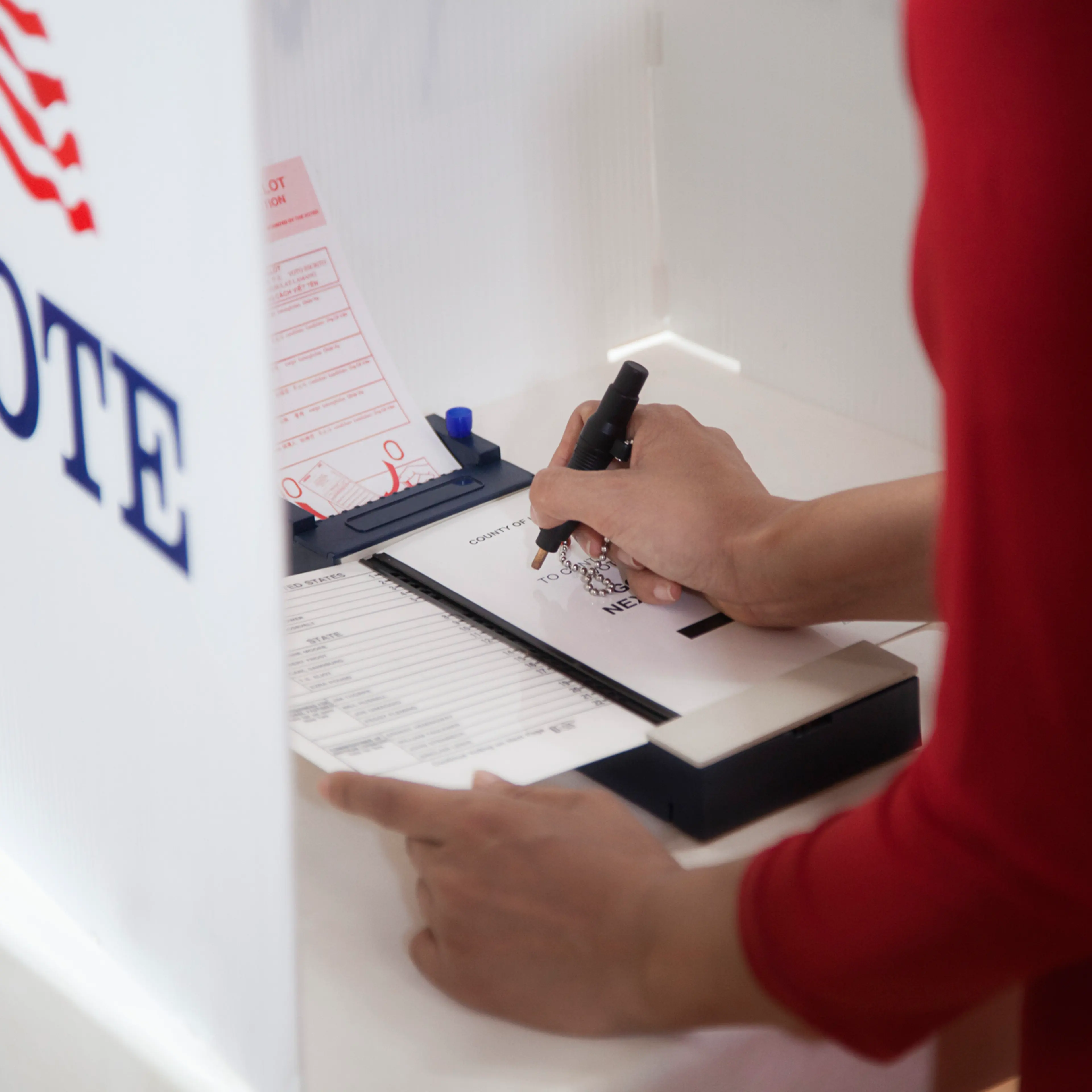 Asian voter voting in polling place