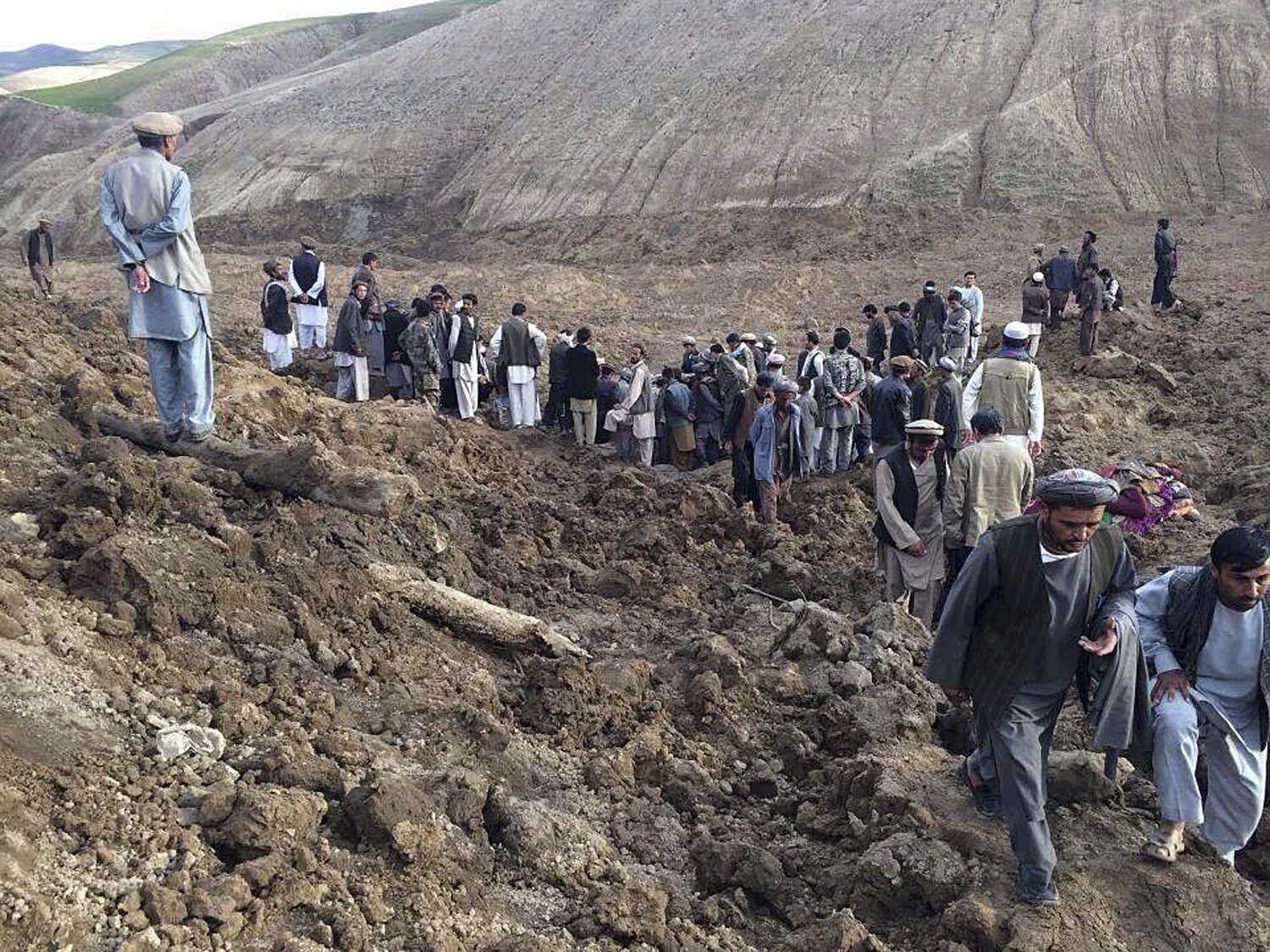 Afghan villagers gather at the site of a landslide at the Argo district in Badakhshan province, May 2, 2014.