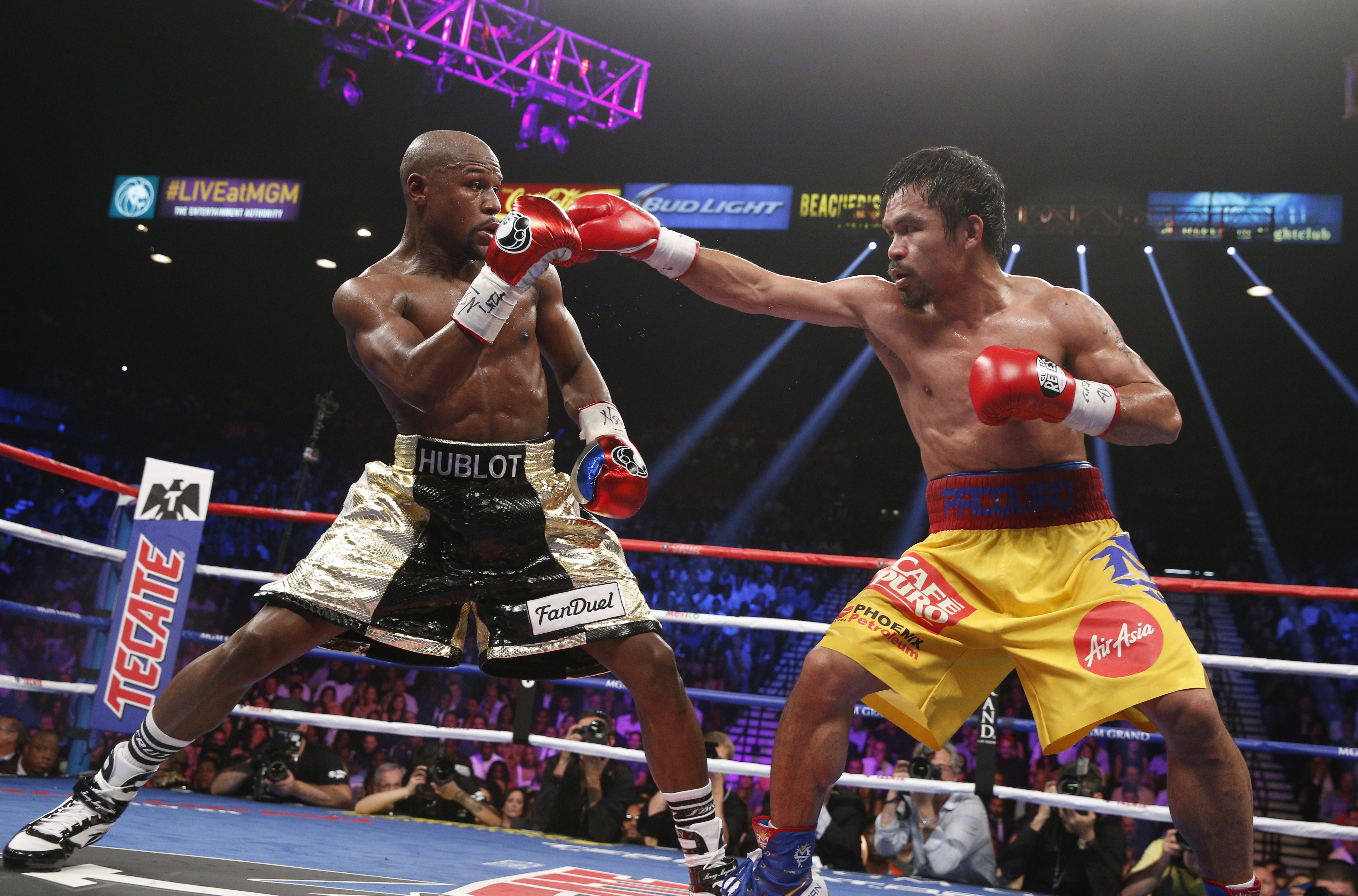 Floyd Mayweather Jr. exchange punches with Manny Pacquiao during their welterweight unification championship bout, May 2, 2015 at MGM Grand Garden Arena in Las Vegas, Nevada.