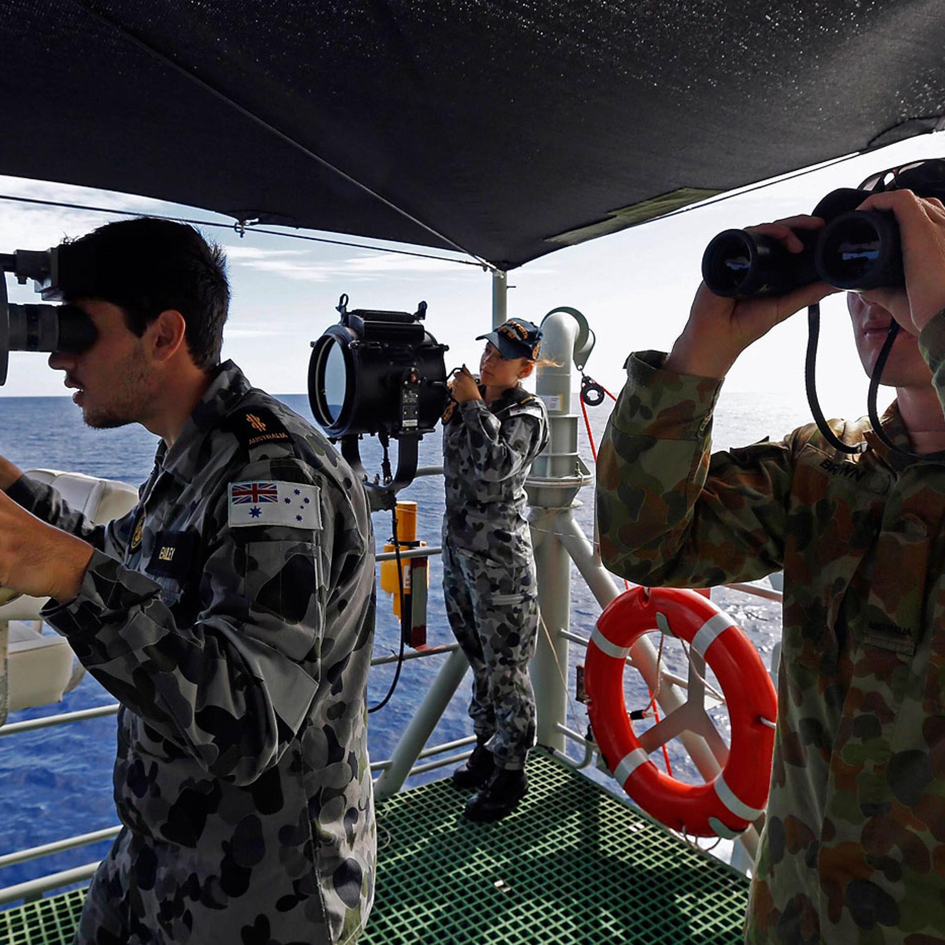 Crewmen aboard the Australian Navy ship HMAS Perth look towards the HMAS Success during manoeuvres as they continue to search for missing Malaysian Airlines flight MH370