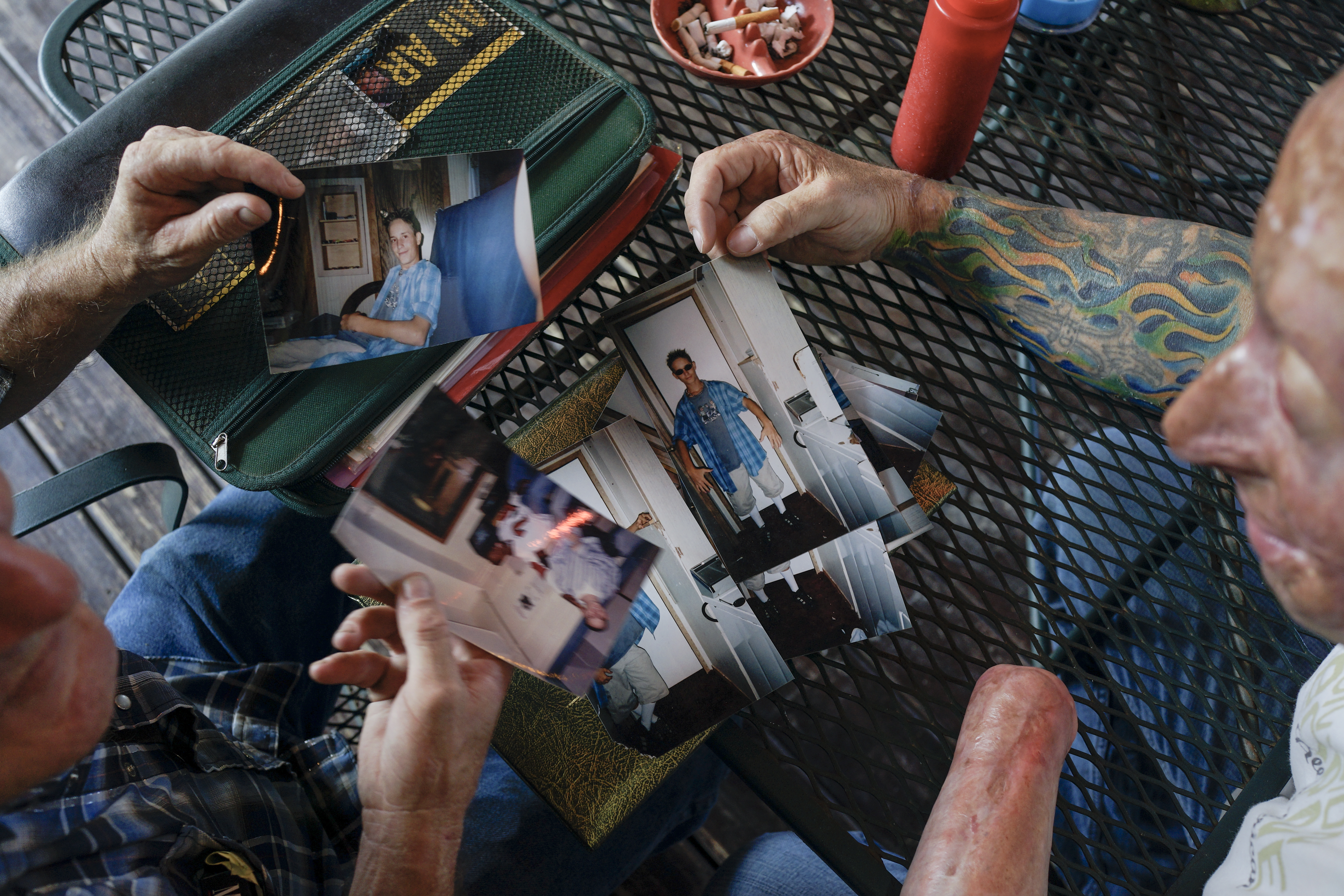 2013. Livingston, TX. USA. Bobby looks at pictures of Rodney McCandless with his father, Lynn. Rodney was killed in the IED explosion that injured Bobby. For years McCandless's family didn't know that anyone had survived the attack until Bobby was able t