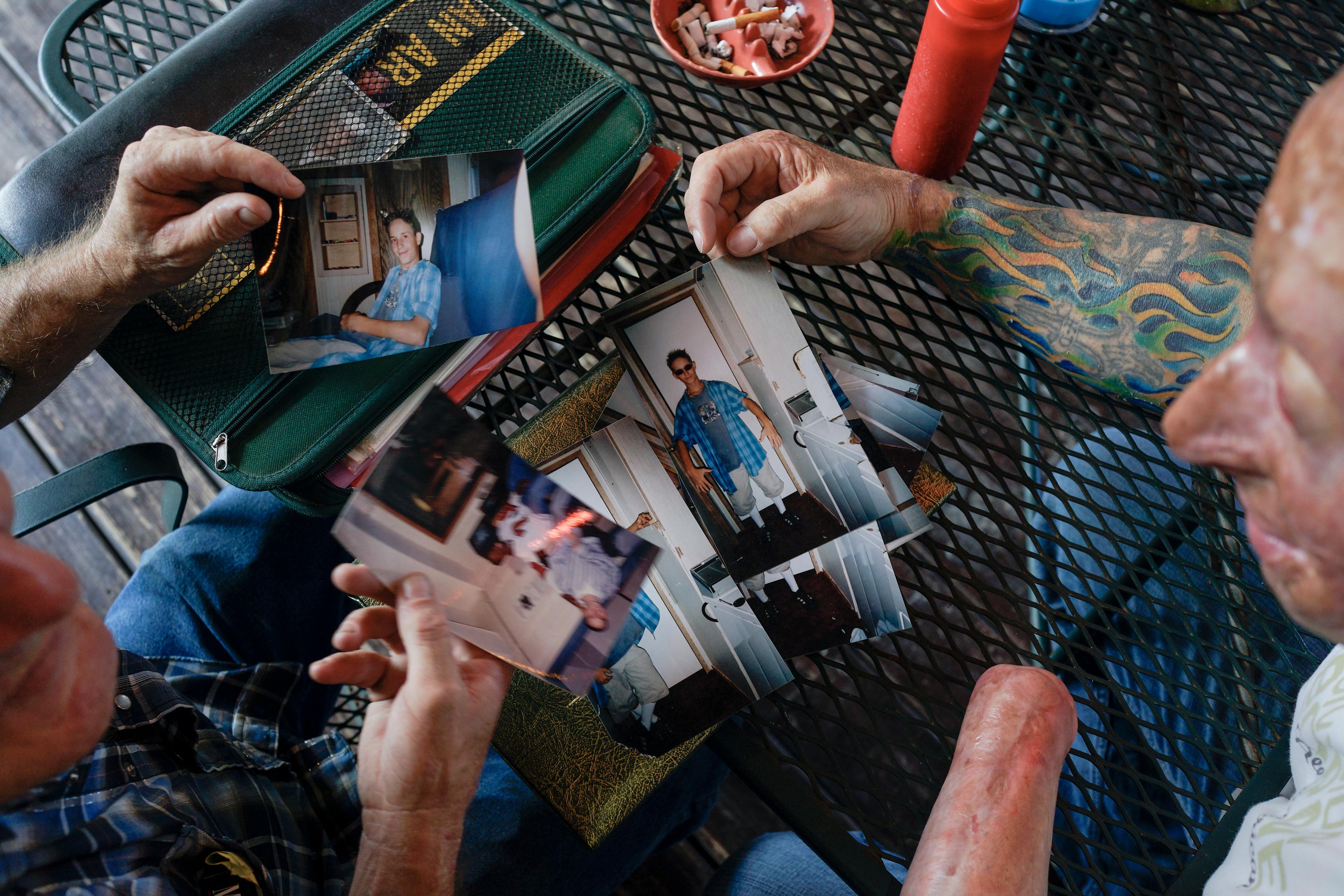 2013. Livingston, TX. USA. Bobby looks at pictures of Rodney McCandless with his father, Lynn. Rodney was killed in the IED explosion that injured Bobby. For years McCandless's family didn't know that anyone had survived the attack until Bobby was able t