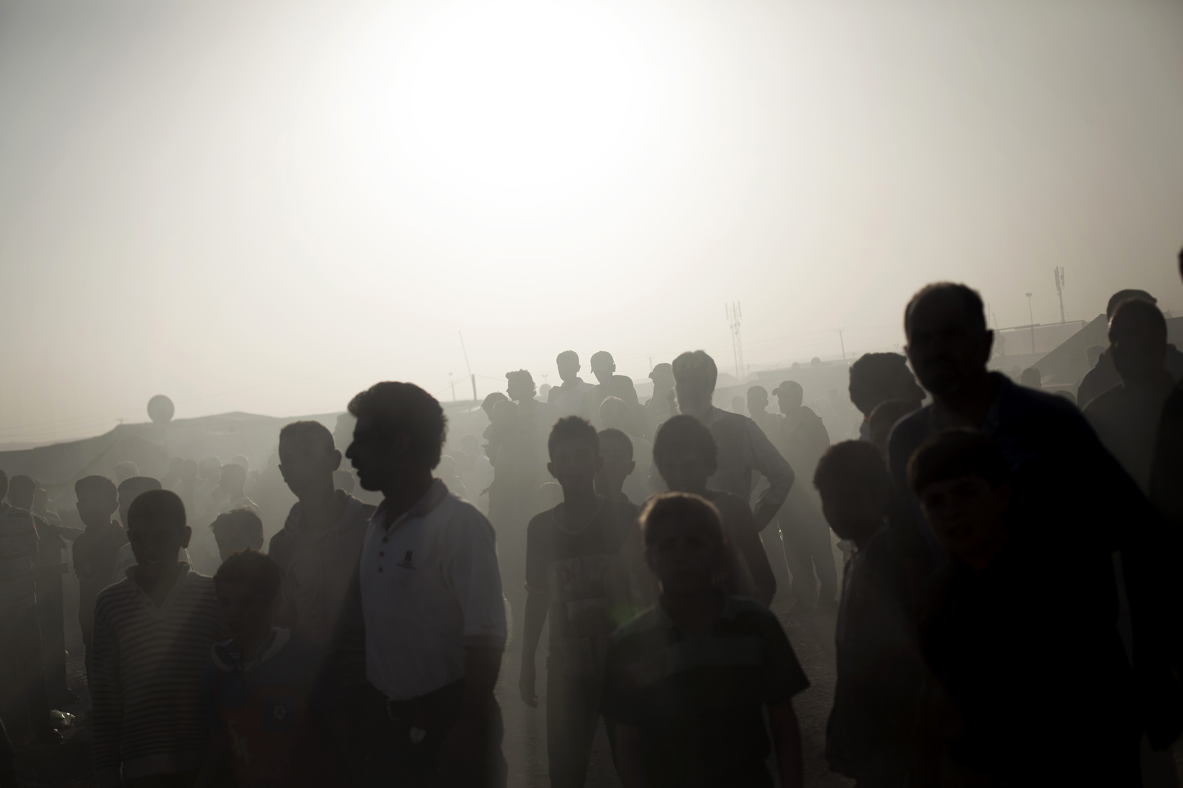 Dozens of Syrian refugees watch a tent and a trailer on fire at the Zaatari Refugee camp near the Syrian border in Jordan, Oct. 22, 2013.
