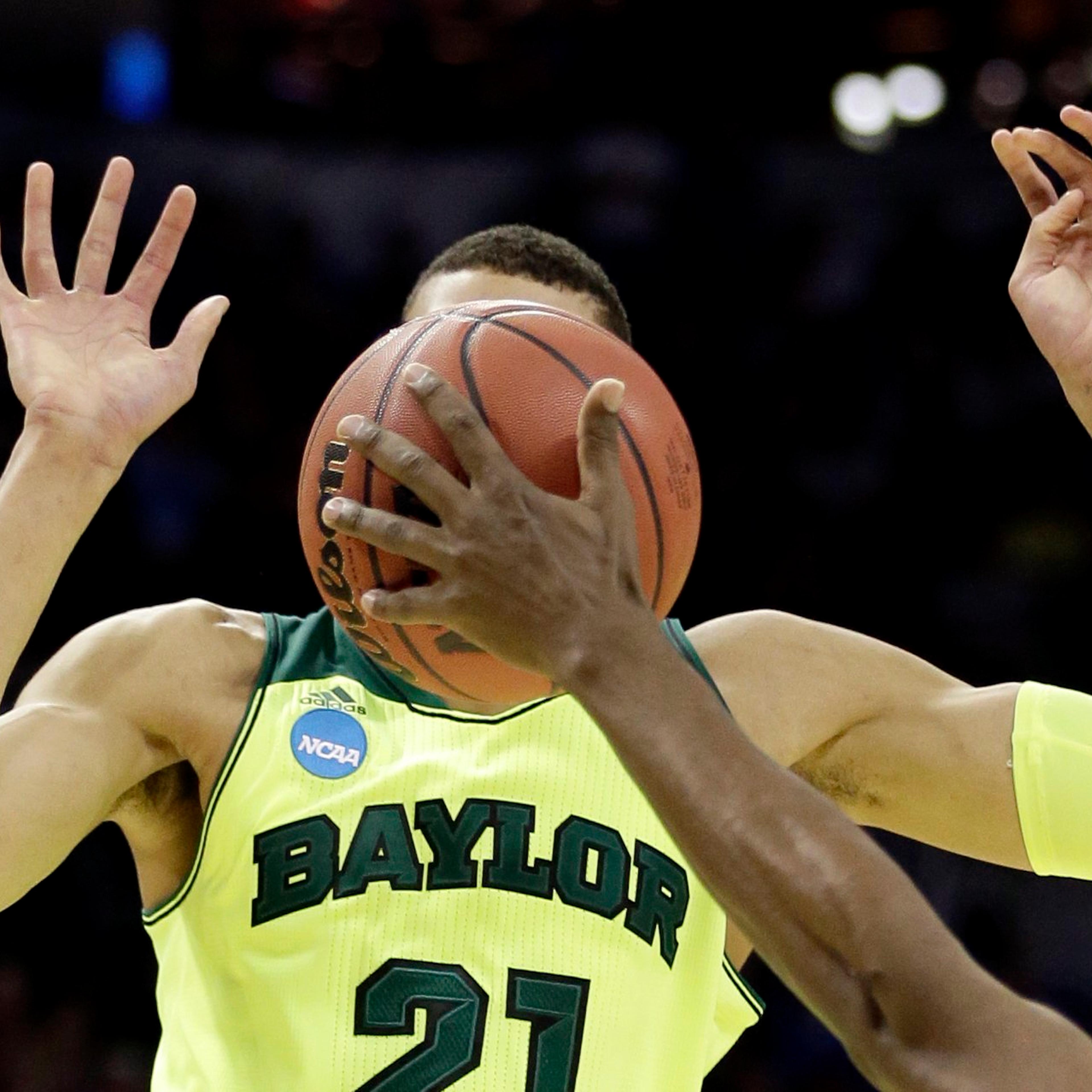 Baylor's Isaiah Austin has his face covered by the ball as Nebraska's Leslee Smith's arm reaches for the ball during the second half of a second-round game in the NCAA college basketball tournament, March 21, 2014, in San Antonio. Baylor won 74-60.