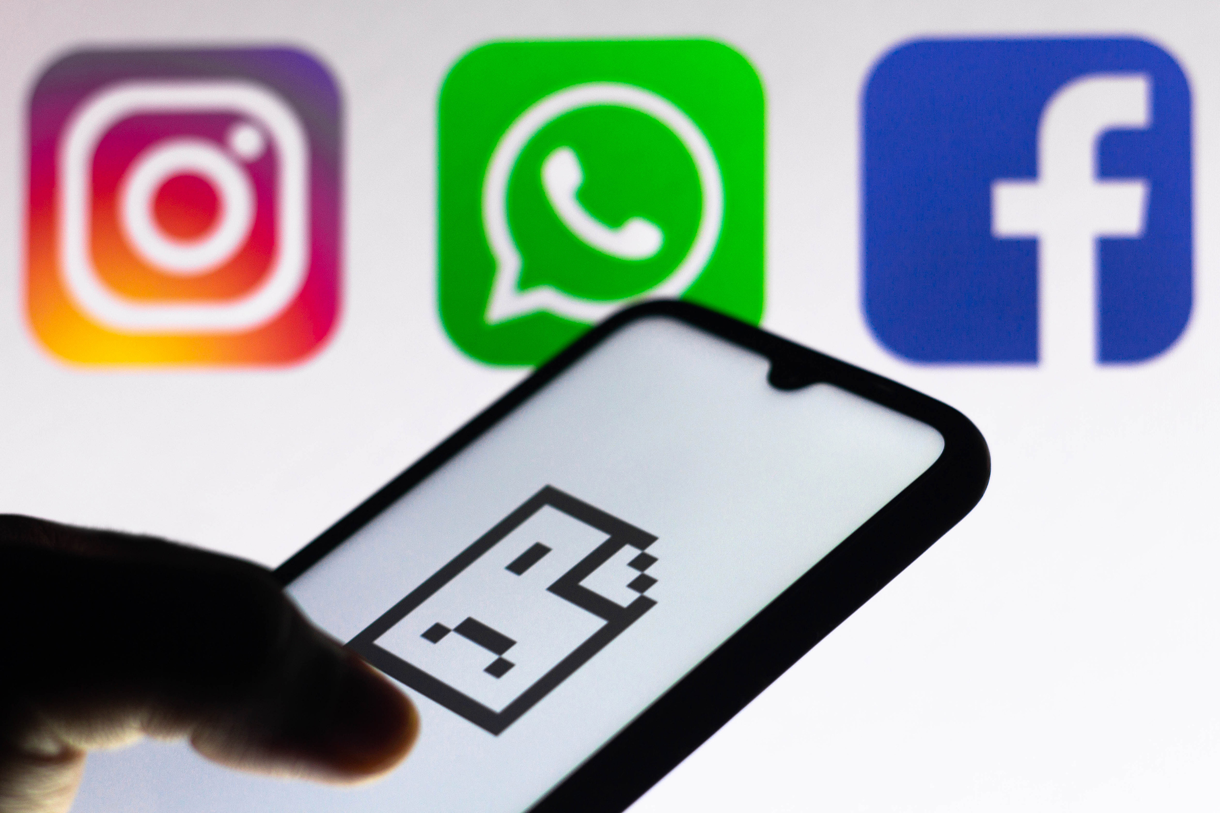 An error icon on a smartphone screen is seen with Instagram, WhatsApp and Facebook logos in the background.