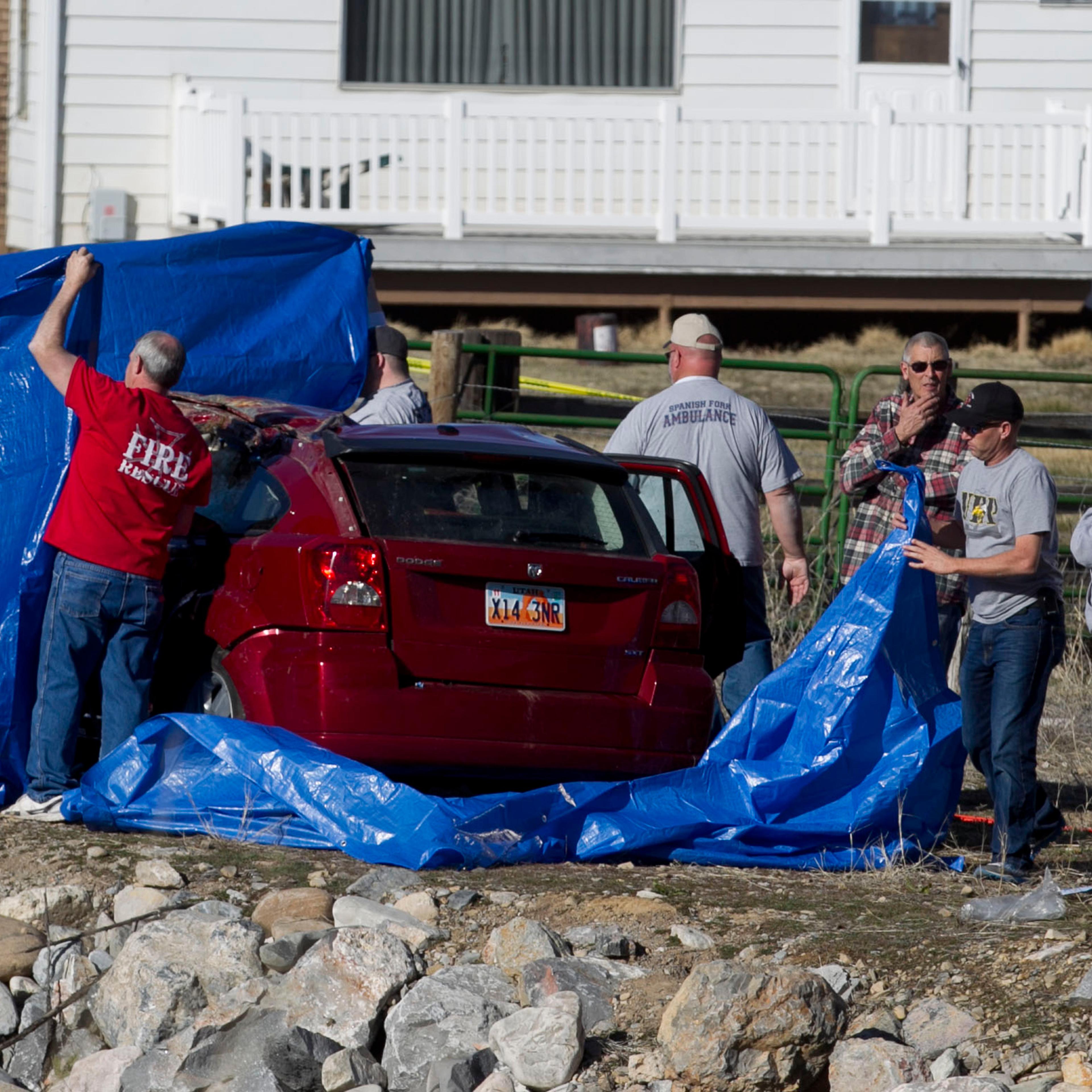 In this March 7, 2015 photo, officials respond to a report of a car crash in a river in Spanish Fork, Utah
