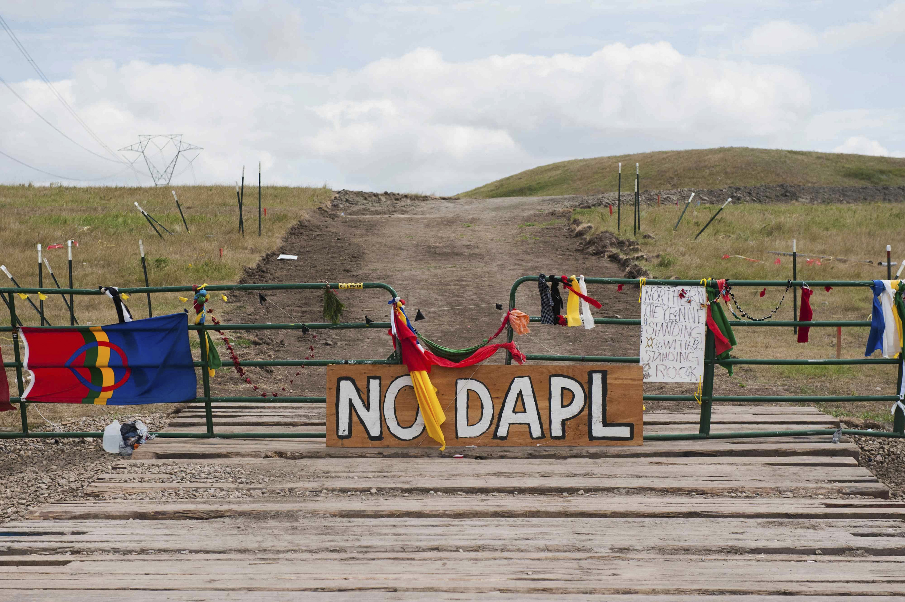 Signs left by protesters demonstrating against the Energy Transfer Partners Dakota Access oil pipeline sit at the gate of a construction access road in Cannon Ball, North Dakota on Sept. 6, 2016.