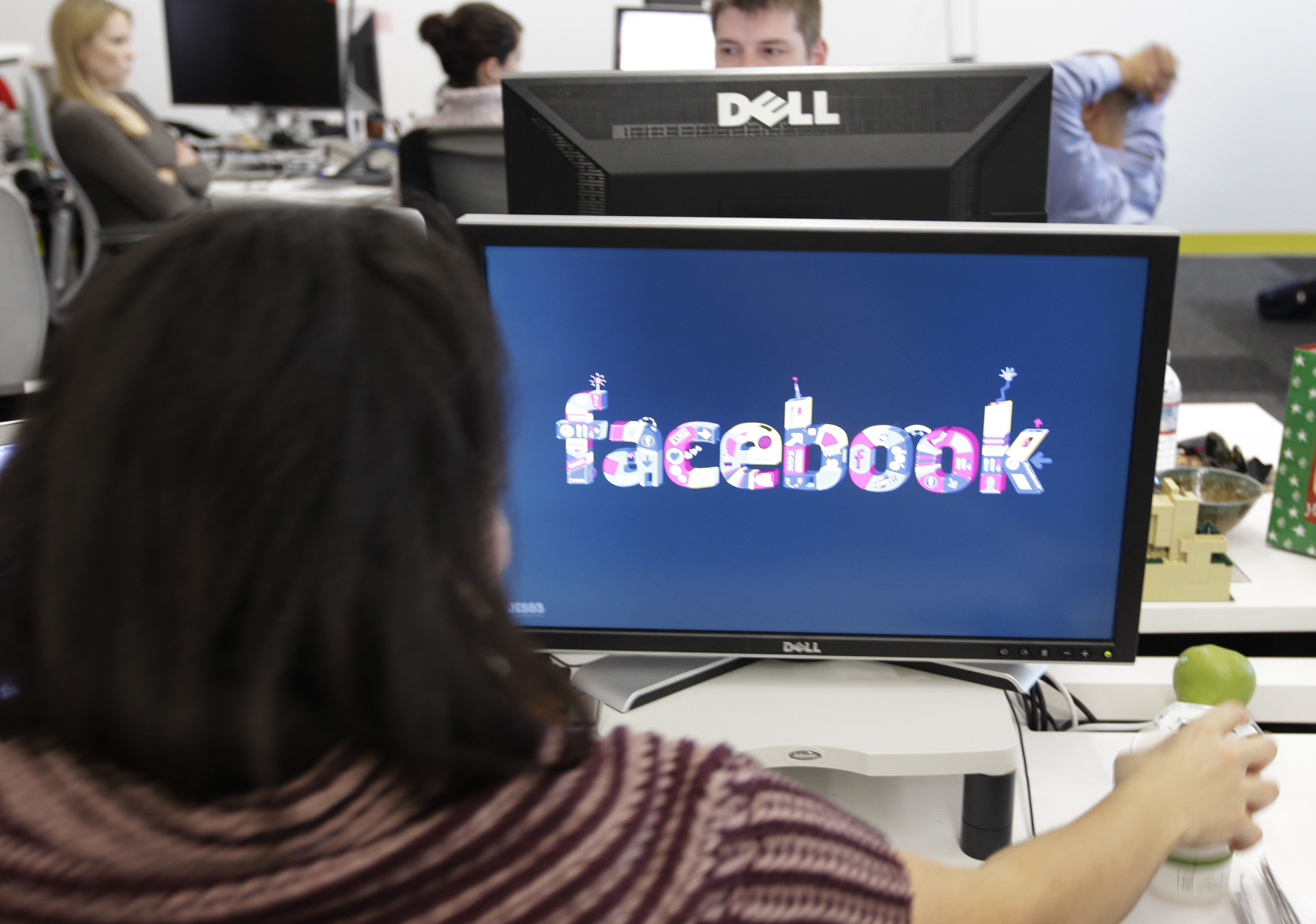 Facebook User Operations Safety Team workers look at reviews at Facebook headquarters in Menlo Park, Calif., Tuesday, Dec. 13, 2011