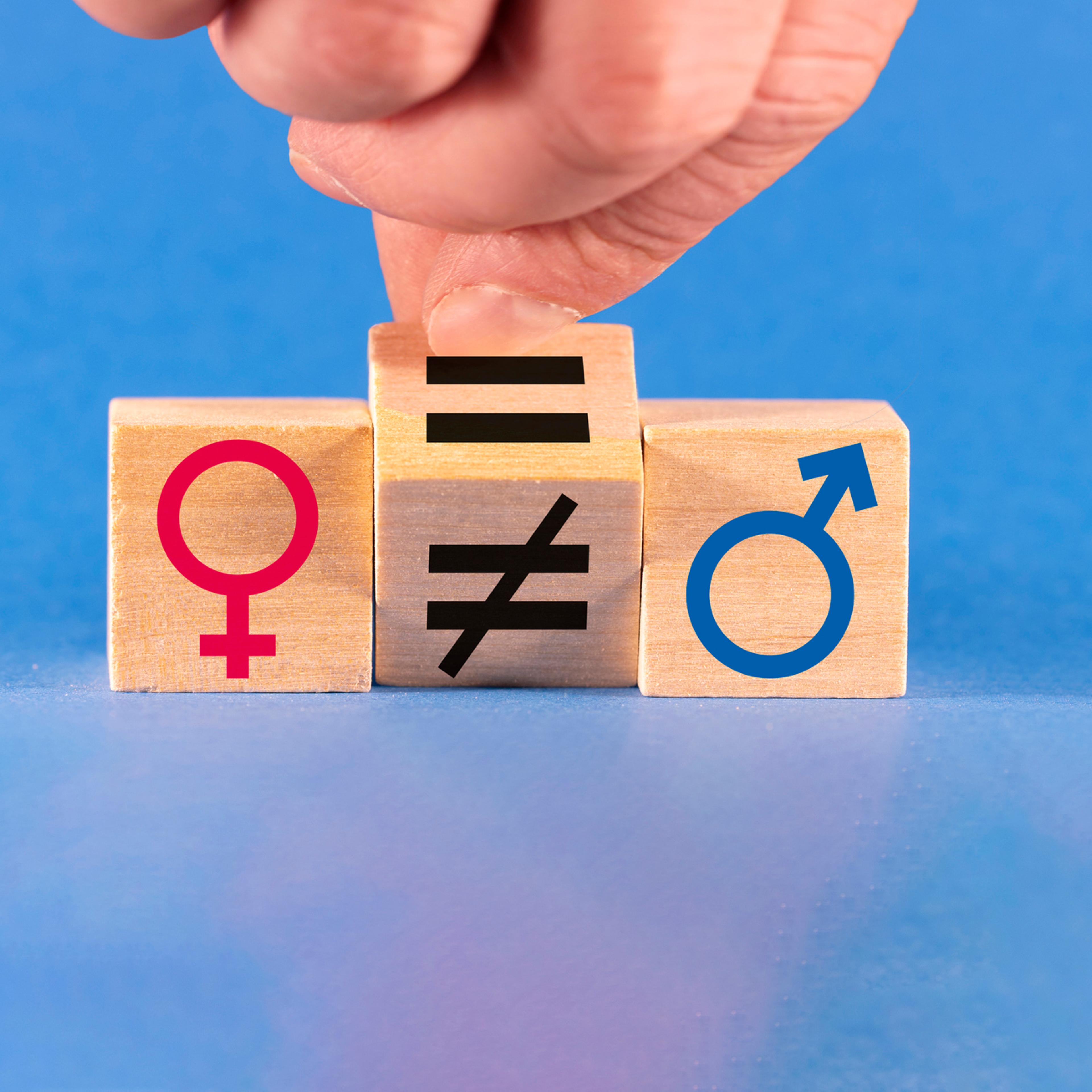 Concept of gender equality. A hand changes an unequal sign to an equal sign between male and female symbols.
