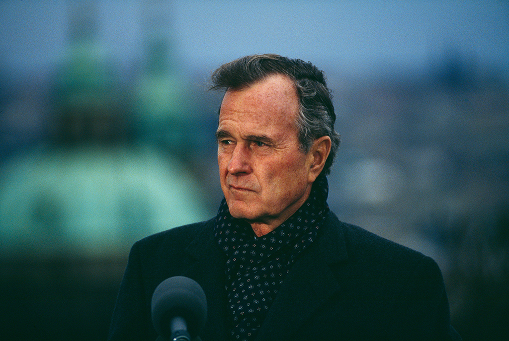 Pres. George H. W. Bush speaking at a podium, during a visit to Prague, 1990.
